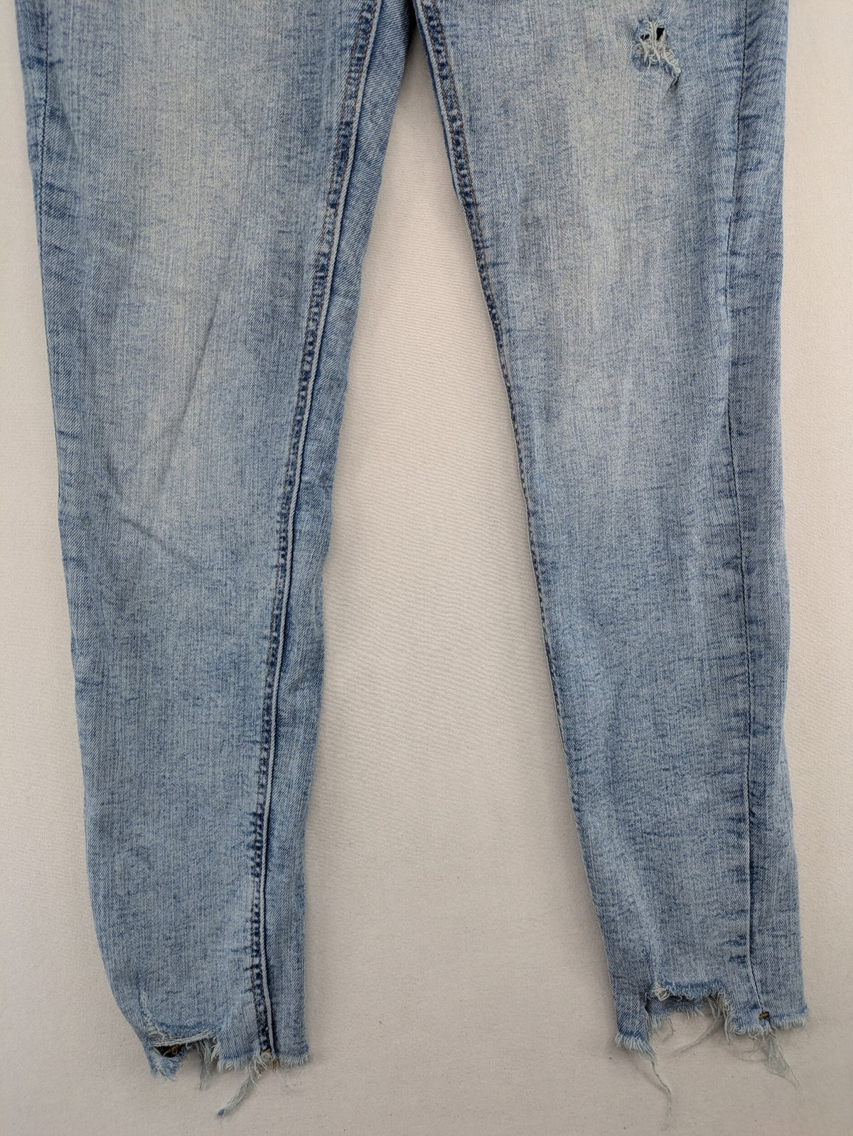Clockhouse blue skinny jeans with distressed details and frayed hem, mid-rise fit.