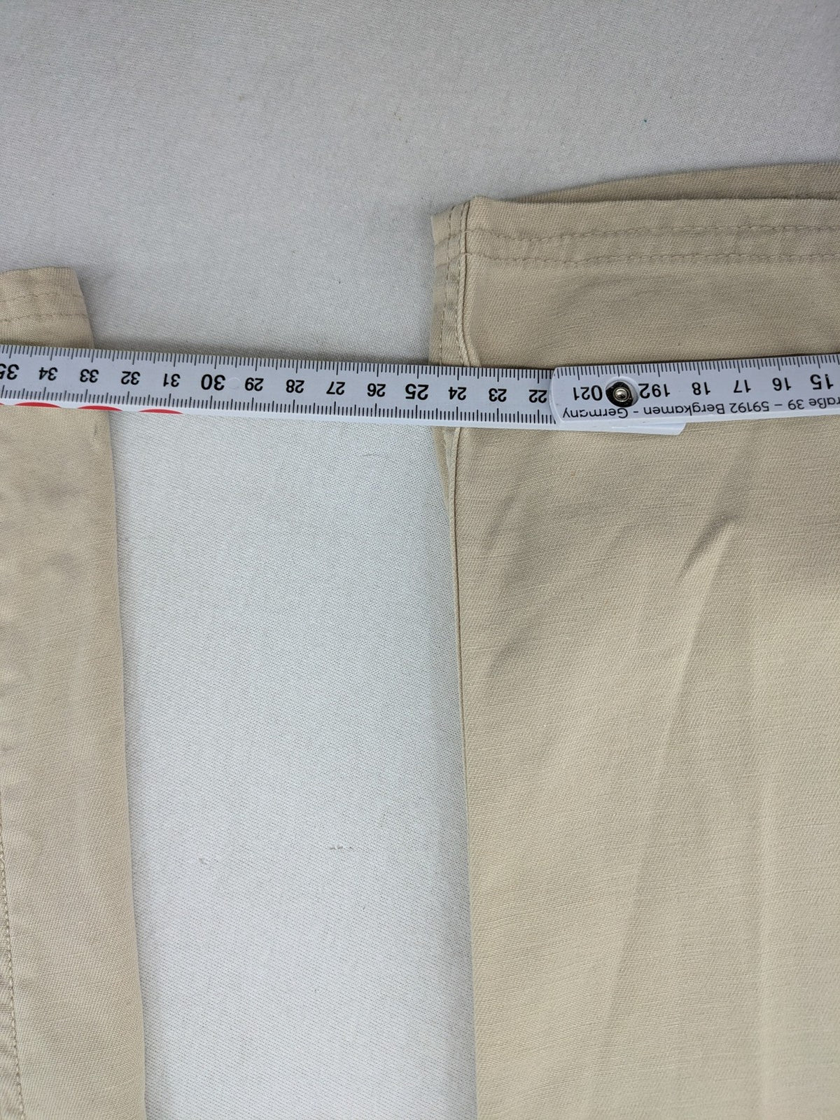 Cottonfield beige cargo pants with multiple pockets and button flaps.