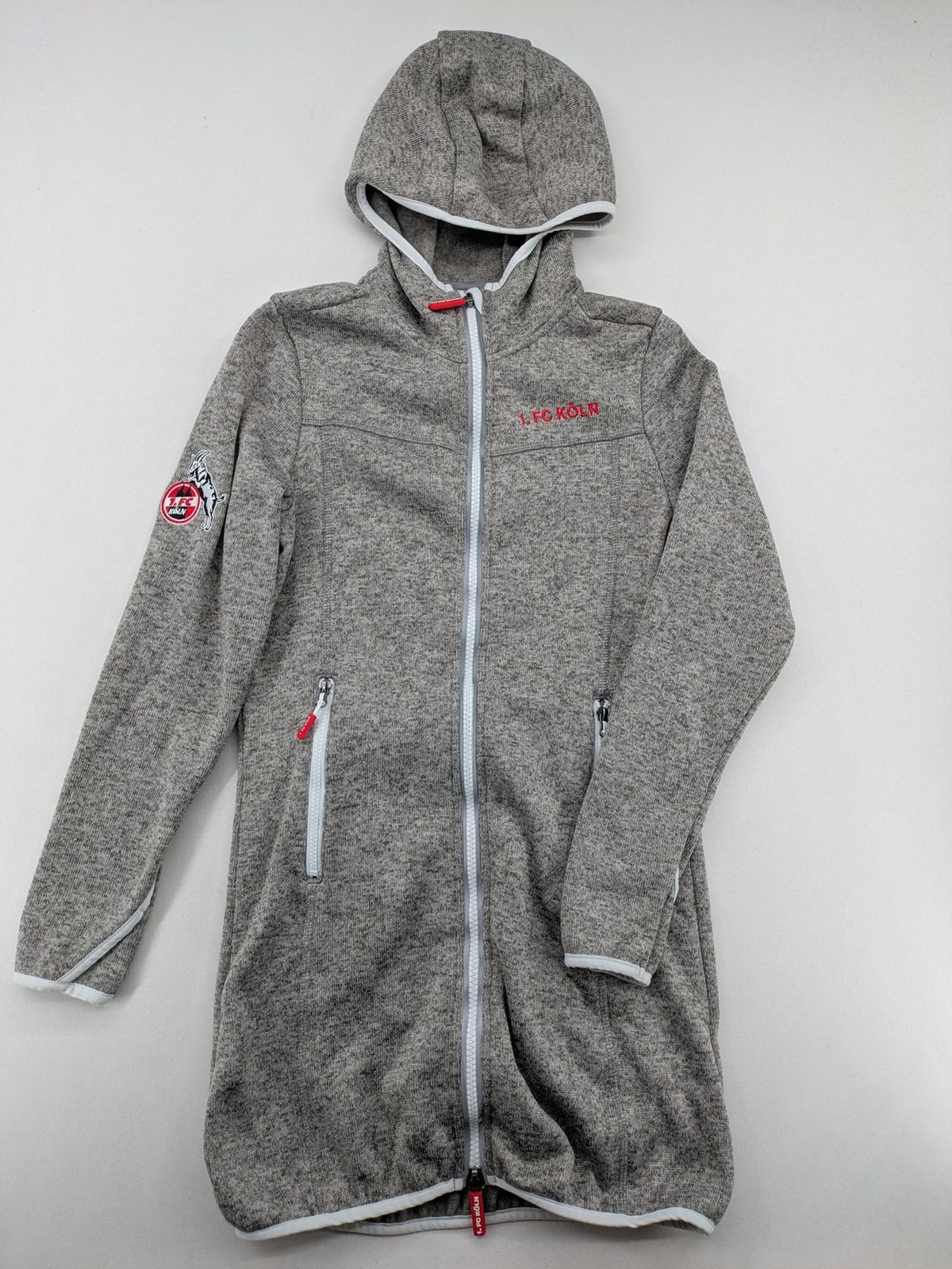 1. FC Köln grey fleece jacket with embroidered logo and hood, perfect for fans.
