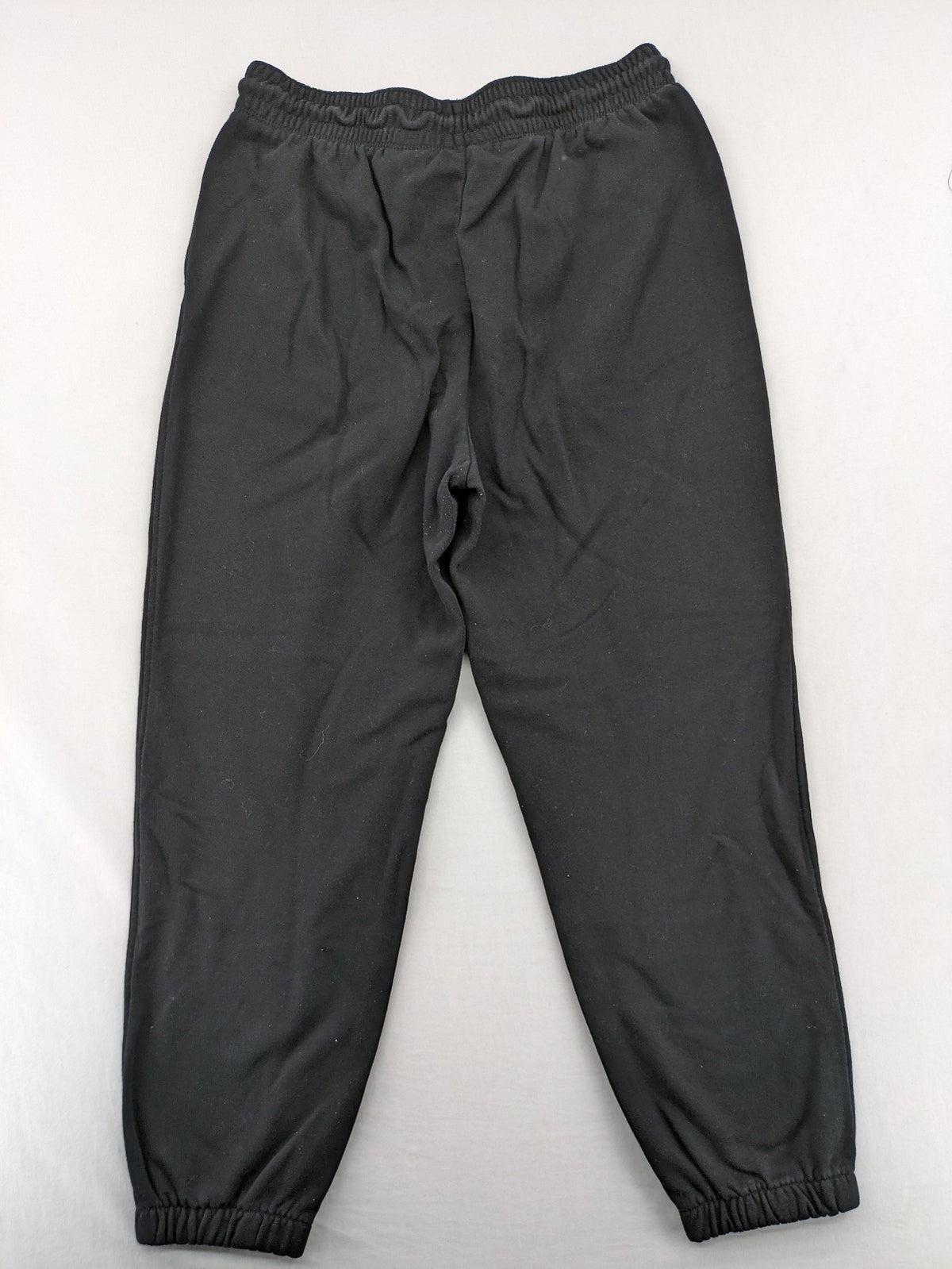 H&M black sweatpants with adjustable drawstring, elastic cuffs, and side pockets.