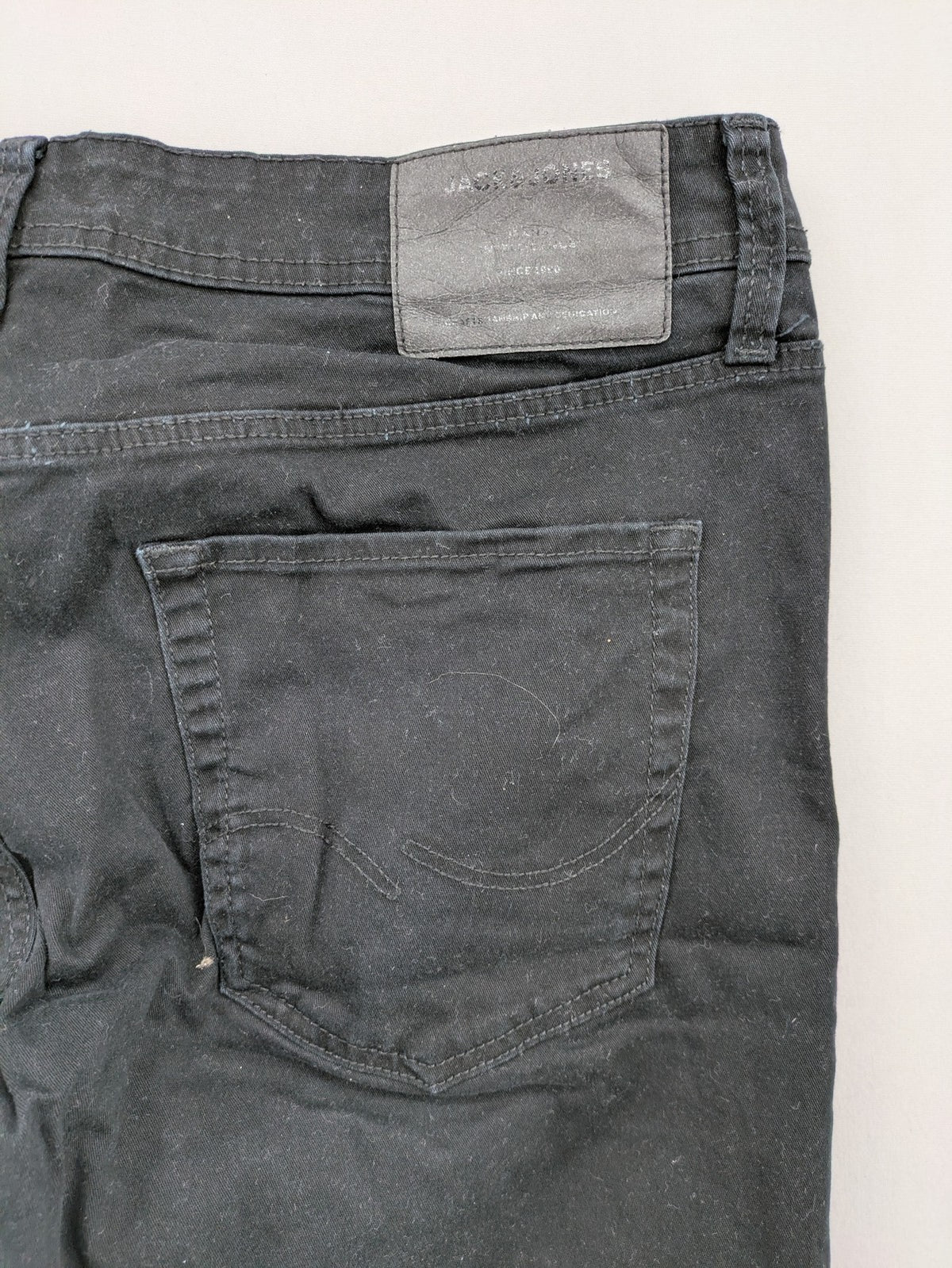 Jack & Jones black slim fit jeans with logo patch and cotton-stretch blend.