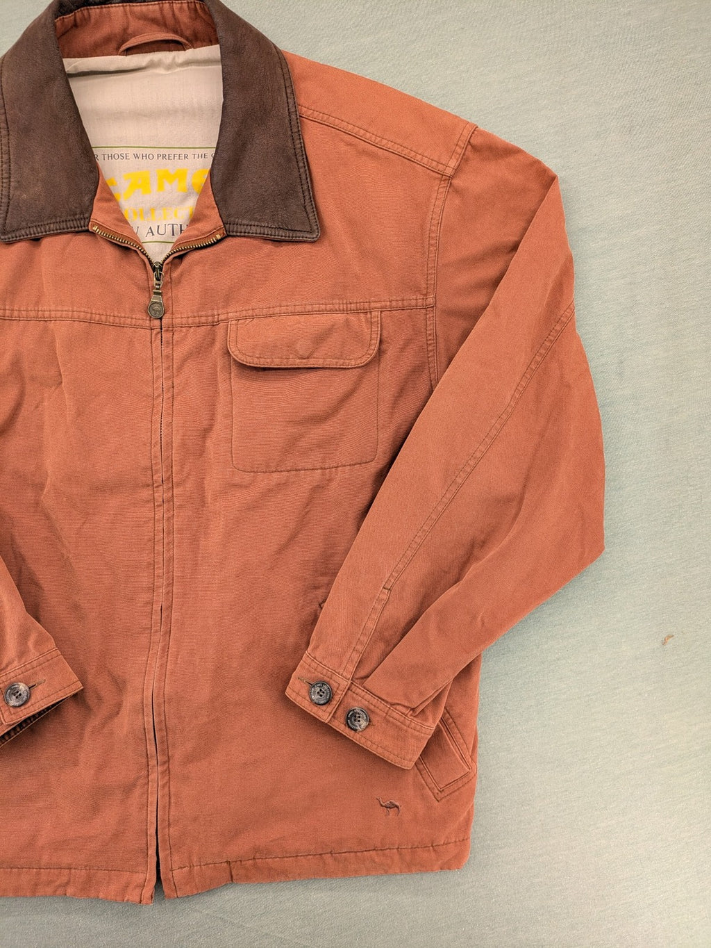 Camel Collection brown jacket with orange contrast collar and embroidered logo.