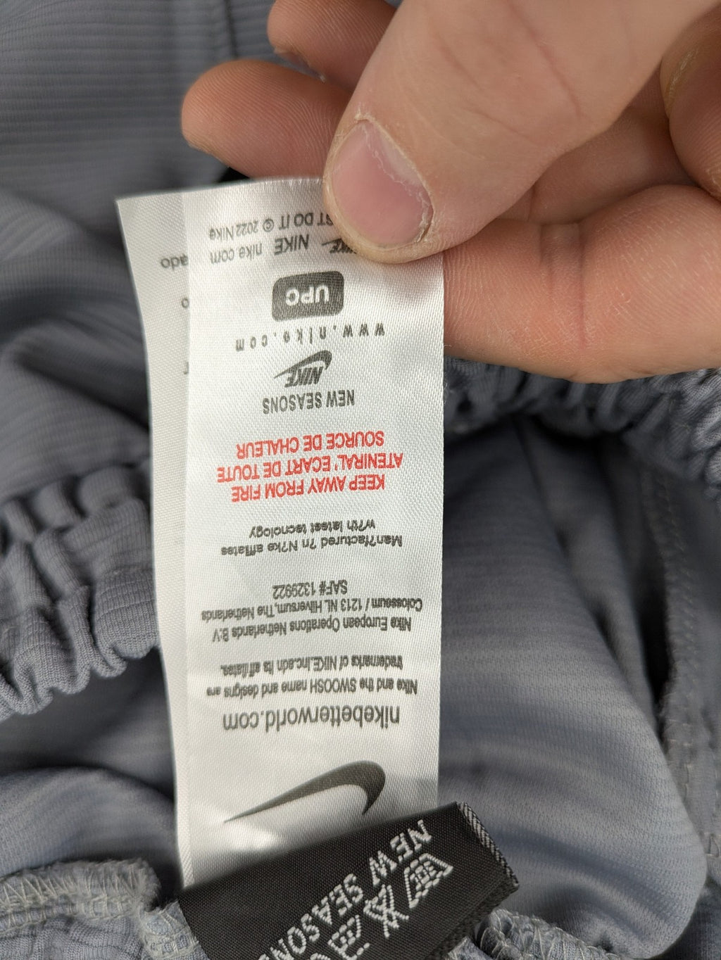 Nike grey shorts with Dri-FIT technology, elastic waistband, and zippered pockets.