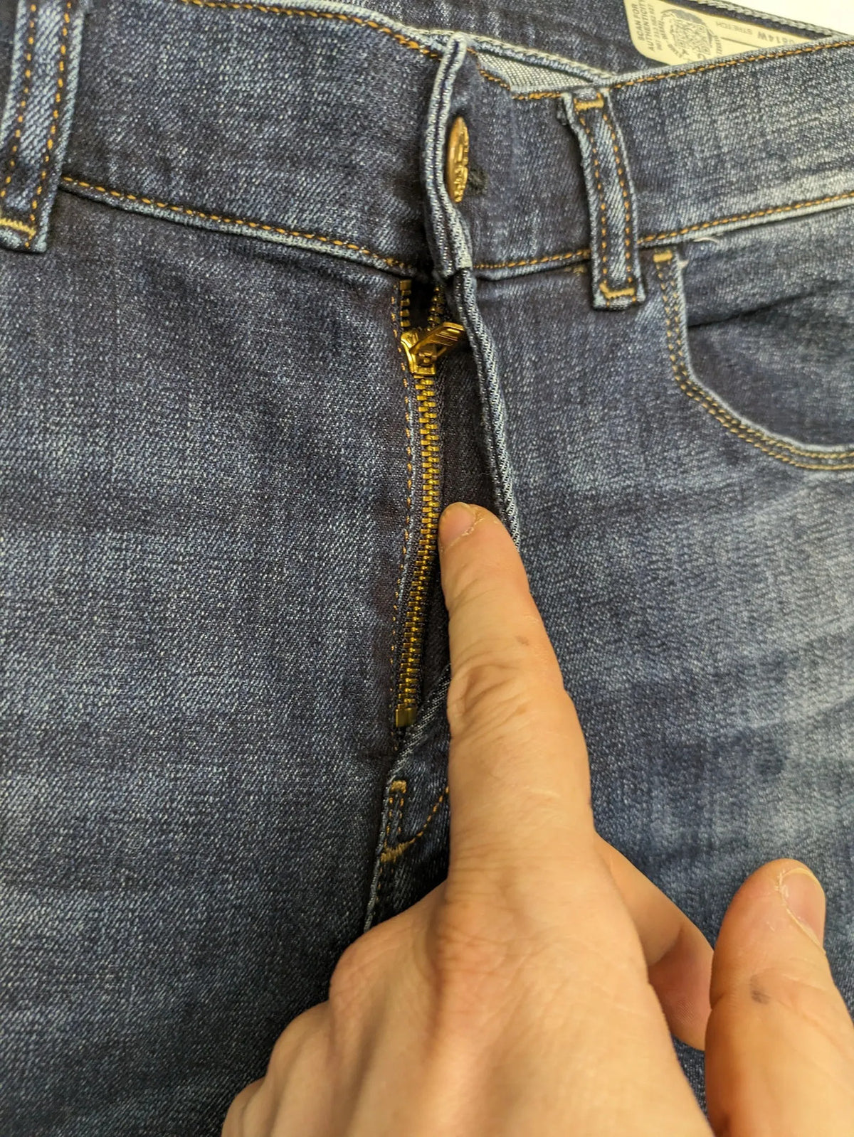 Diesel blue straight jeans with regular waist, dark wash, and stretch material.