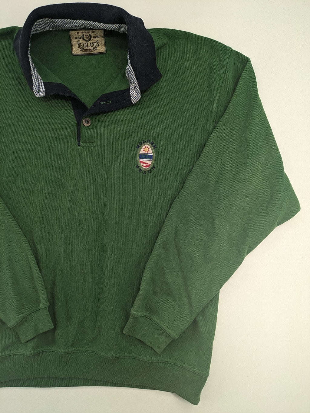 Headlands green turtle neck jumper with gingham collar and "Golden Beach" embroidery.