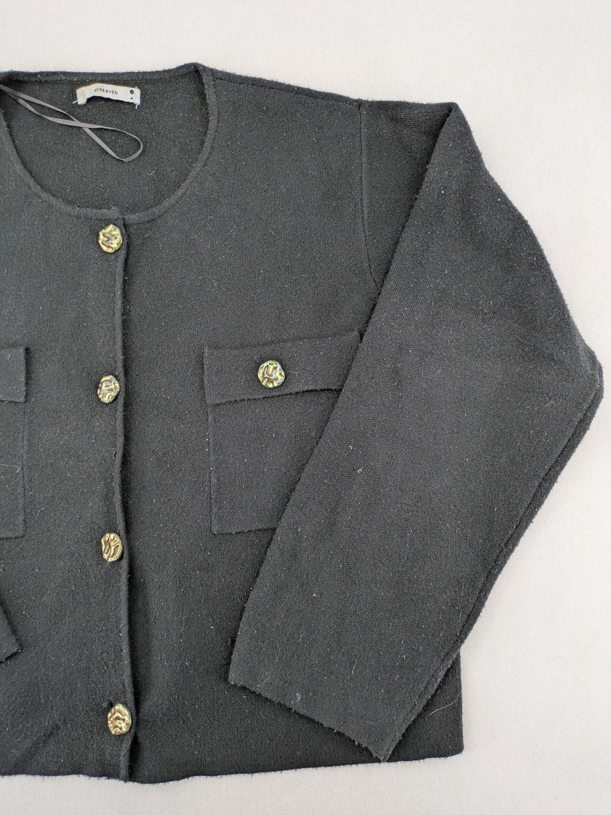 Reserved gold turtle neck jumper with black knit, gold button details and front pockets.