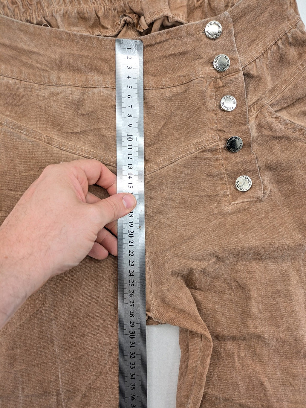 TREDY brown high-waist pants with decorative button placket and elastic waistband, soft knit texture.
