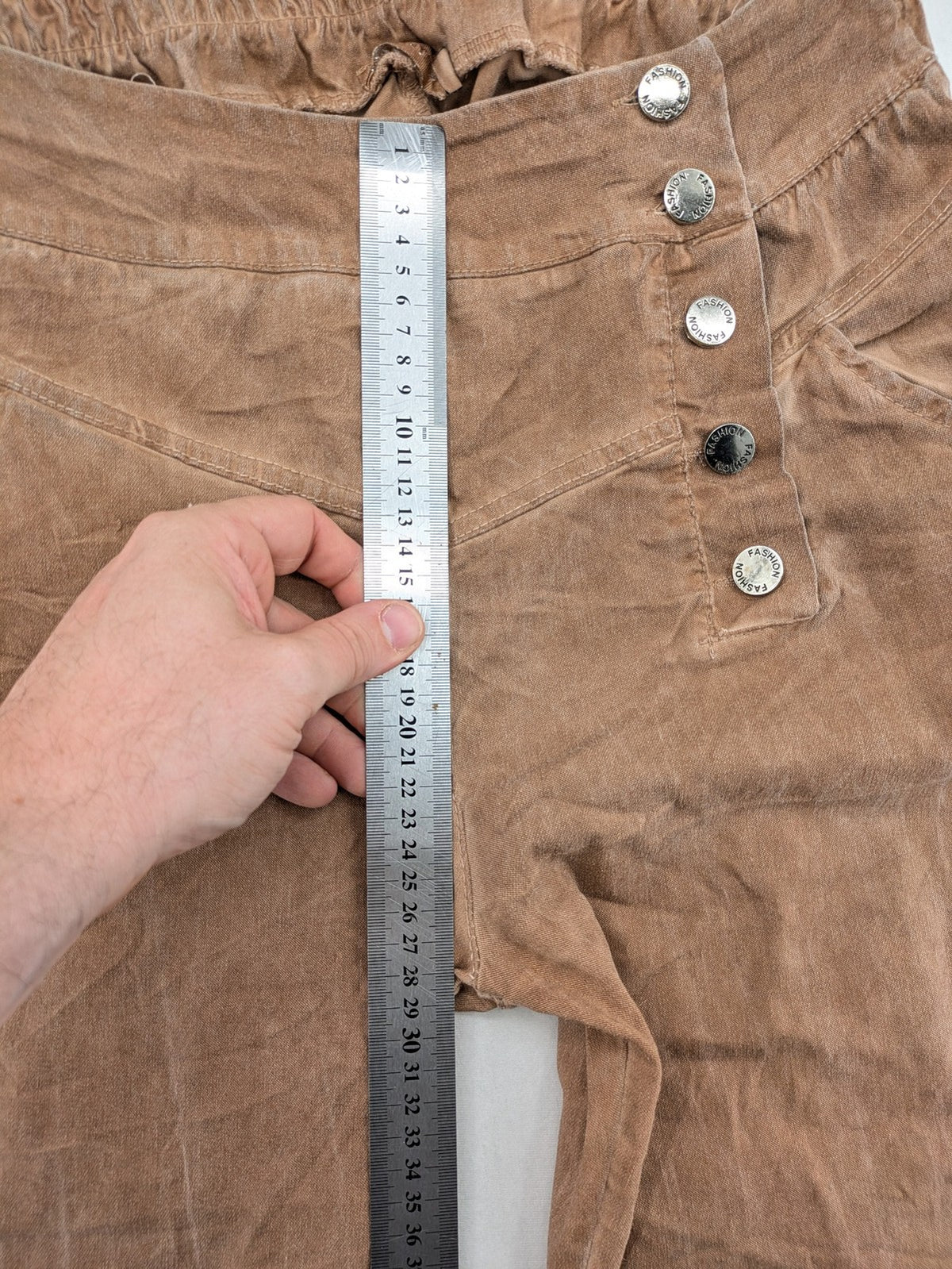 TREDY brown high-waist pants with decorative button placket and elastic waistband, soft knit texture.