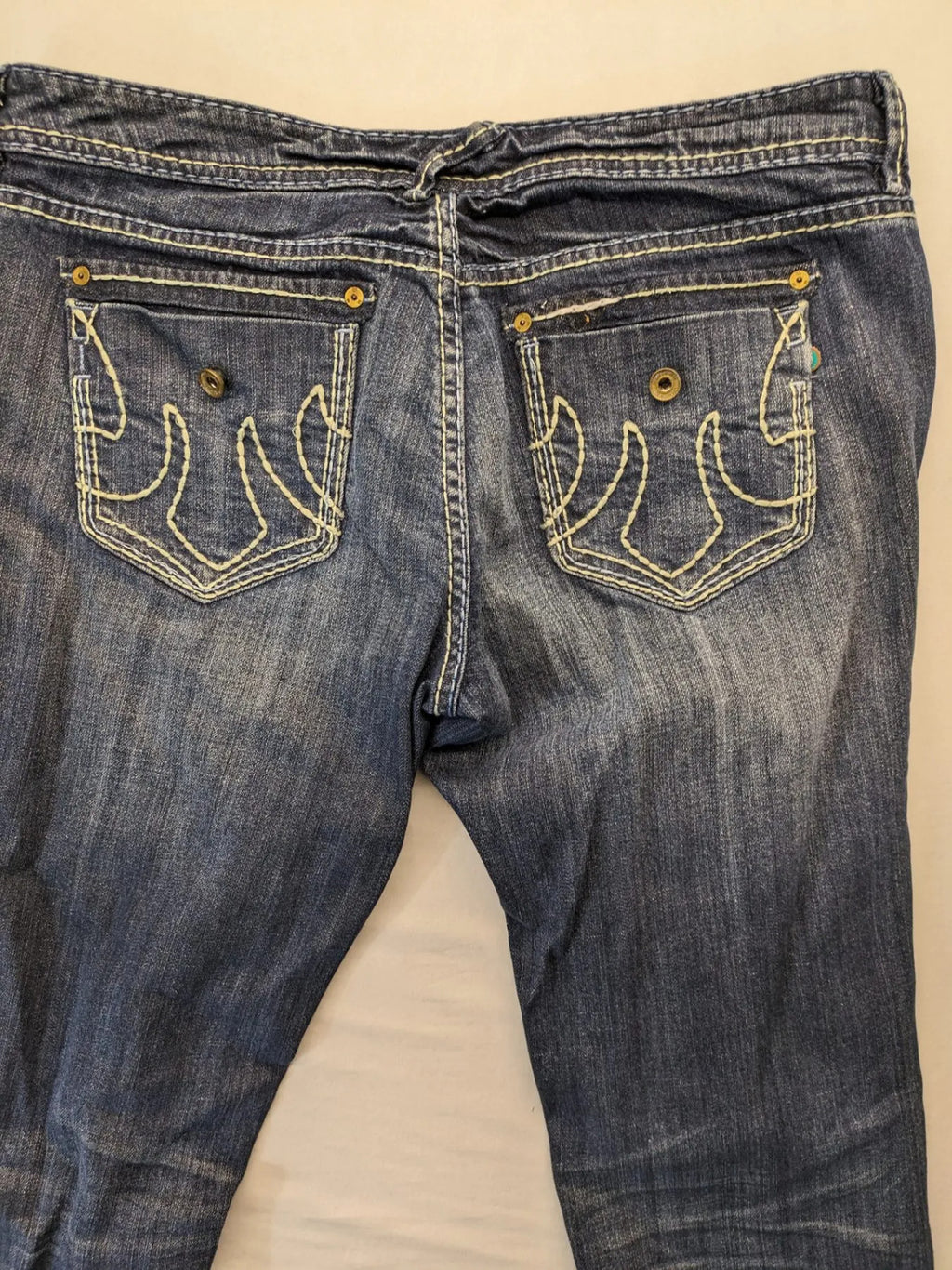 Rhodes blue skinny jeans with decorative studs and intricate embroidery on back pockets.
