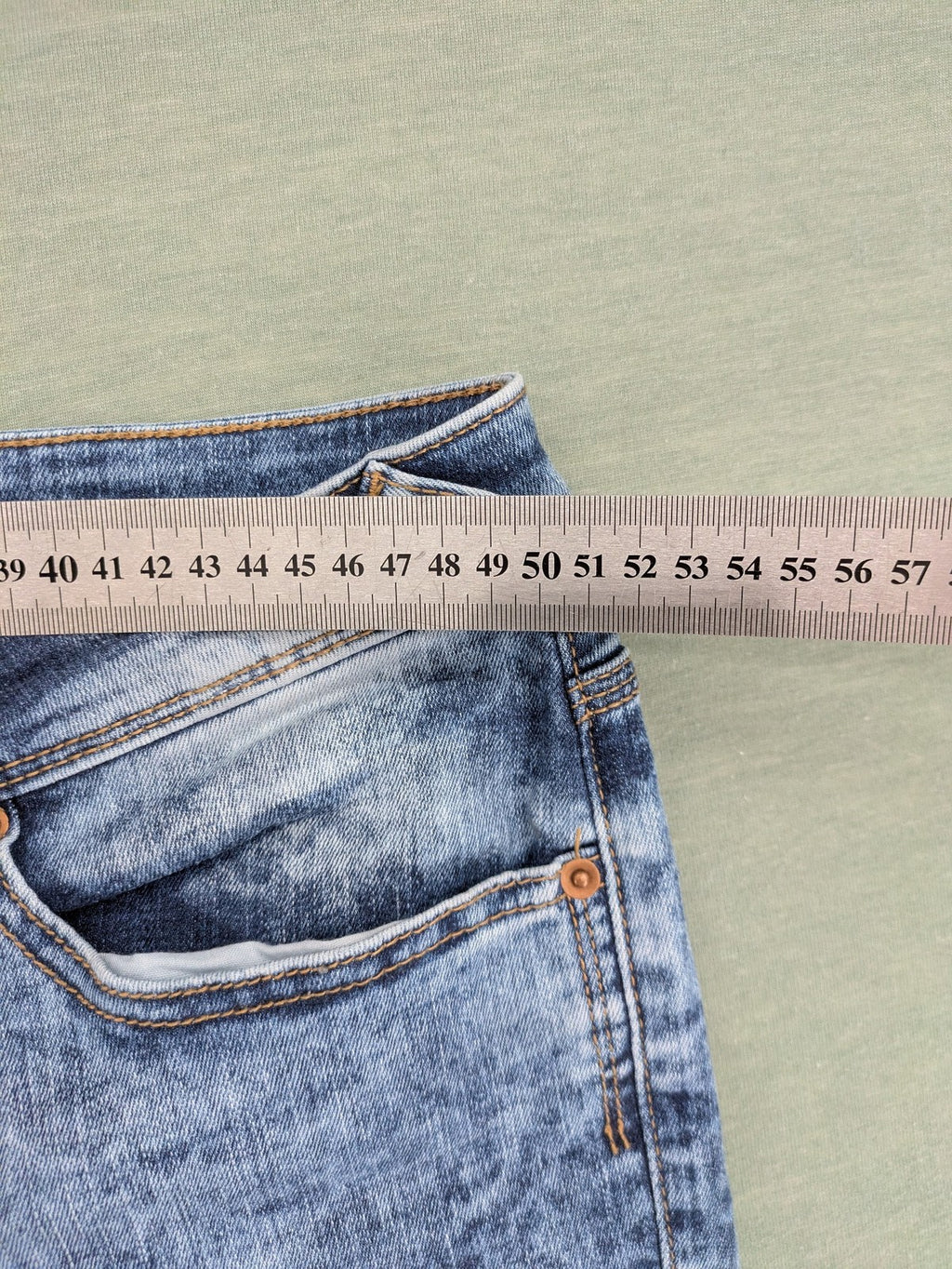 Janina blue slim fit jeans with acid wash, destroyed details, and button fly.