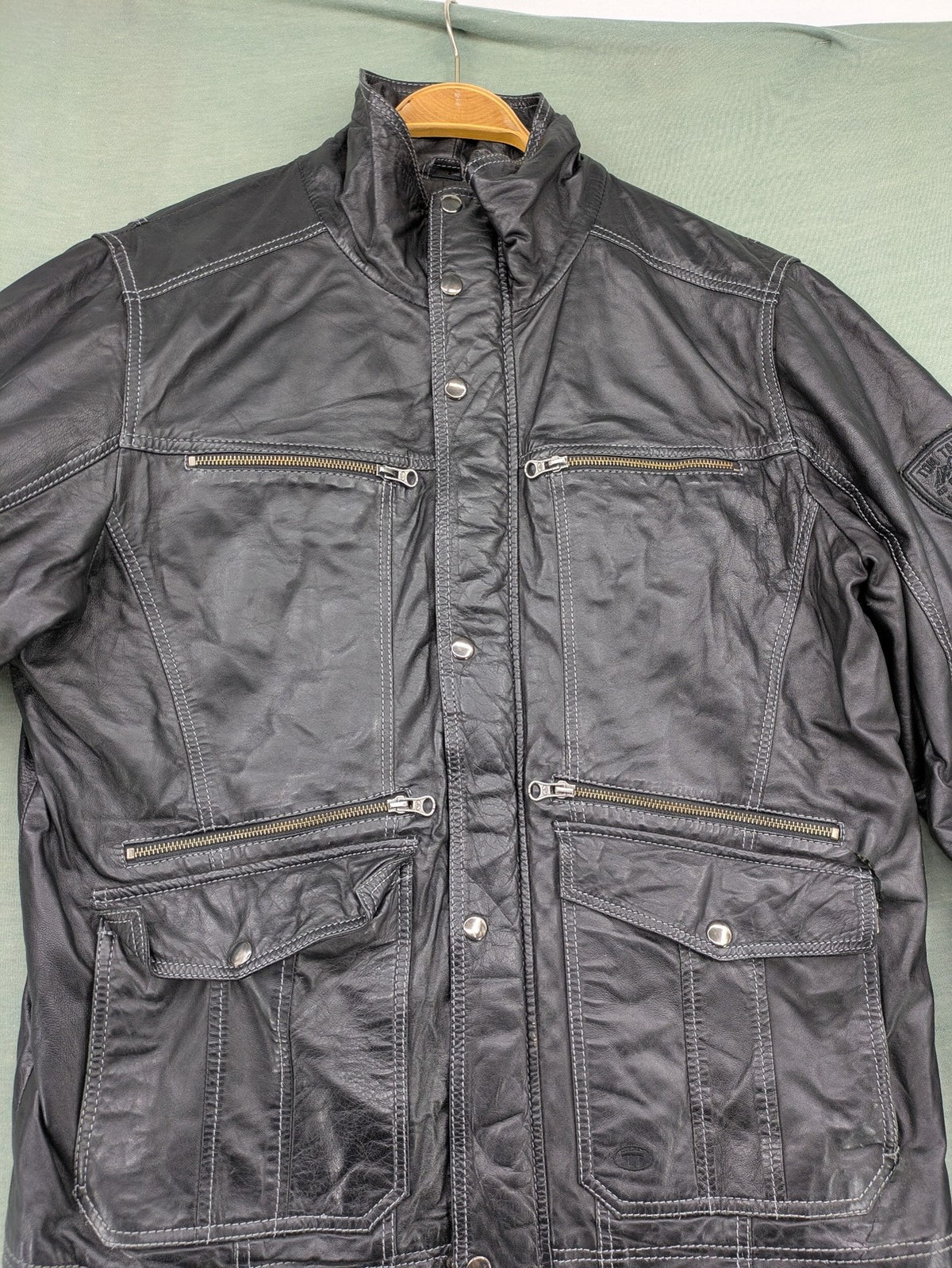 Tom Tailor black leather jacket vintage style with multiple pockets and contrast stitching.