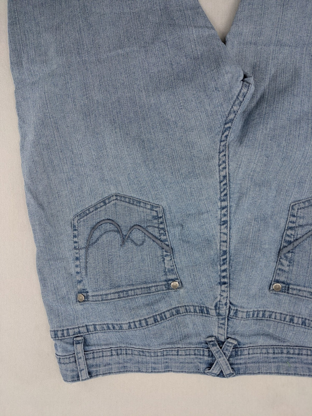 Capri blue straight jeans with 5-pocket design and embroidered details on back pockets.