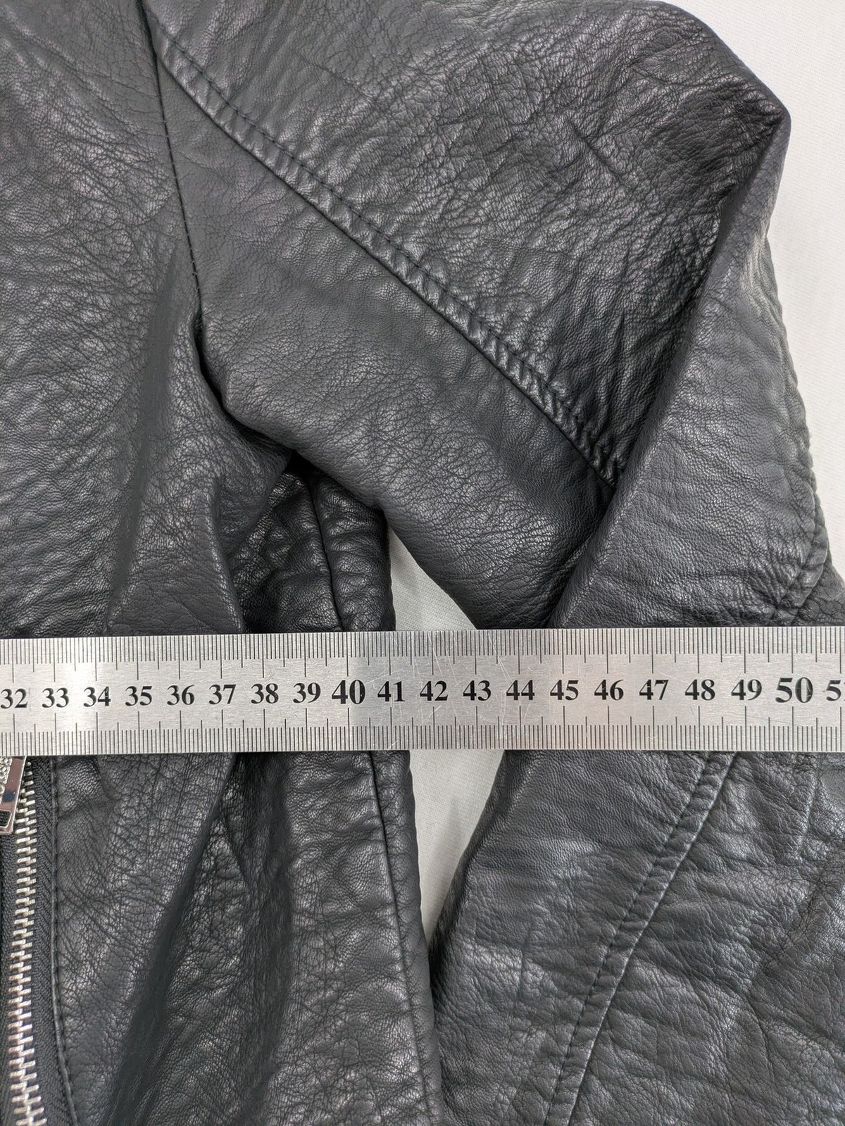 Guess black faux leather biker jacket with asymmetric zipper and multiple zip pockets.
