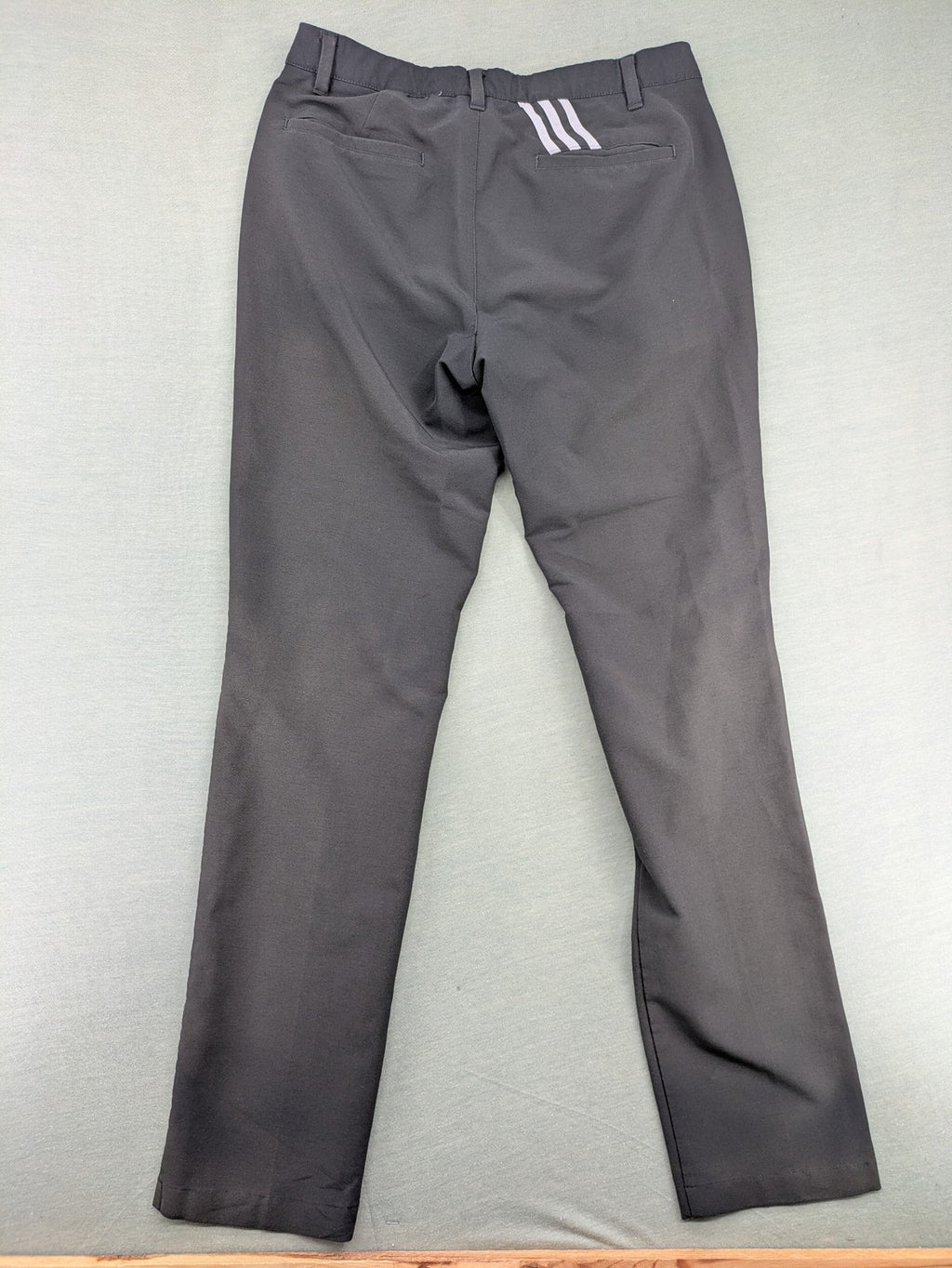 Adidas grey pants with 3-stripe logo, flat-front design, made from performance material.