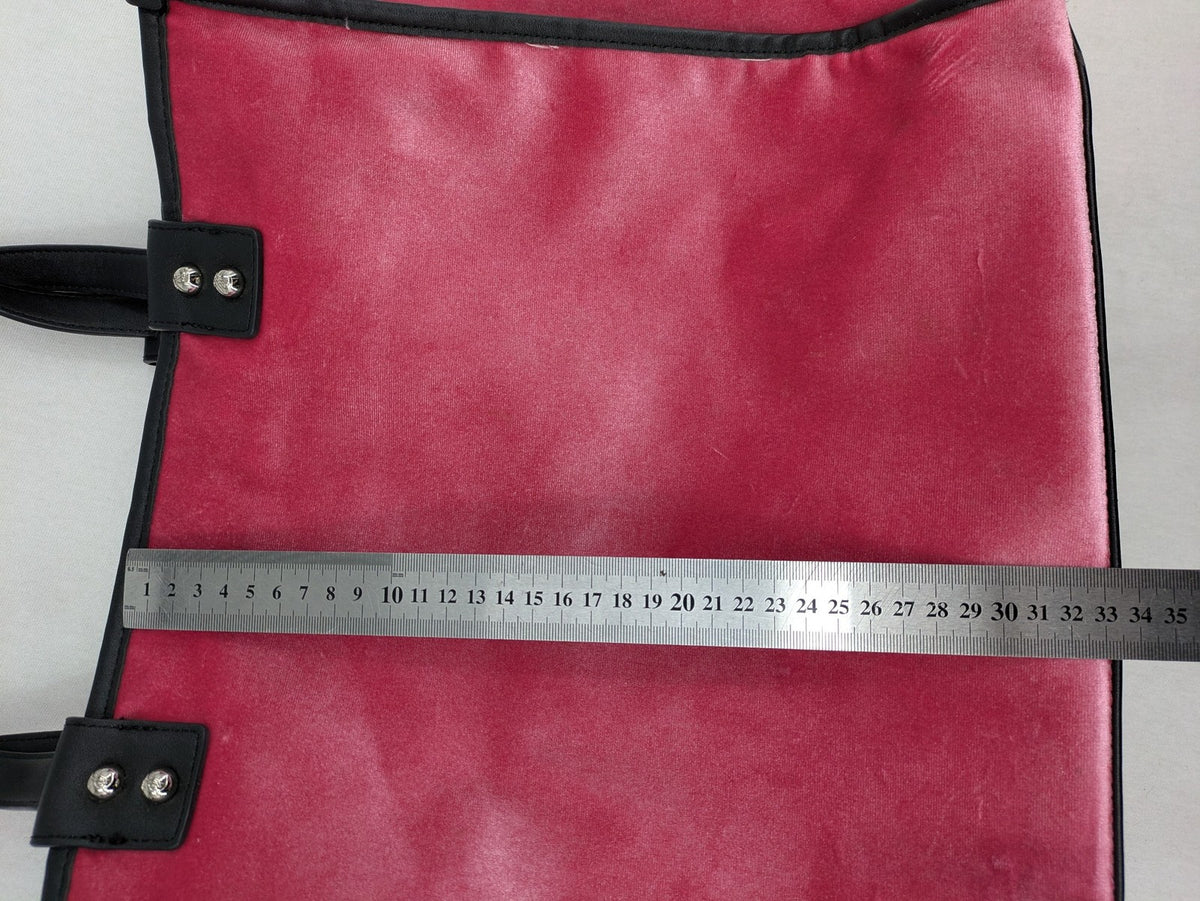Juicy Couture pink velour handbag with oversized black logo and faux leather straps.