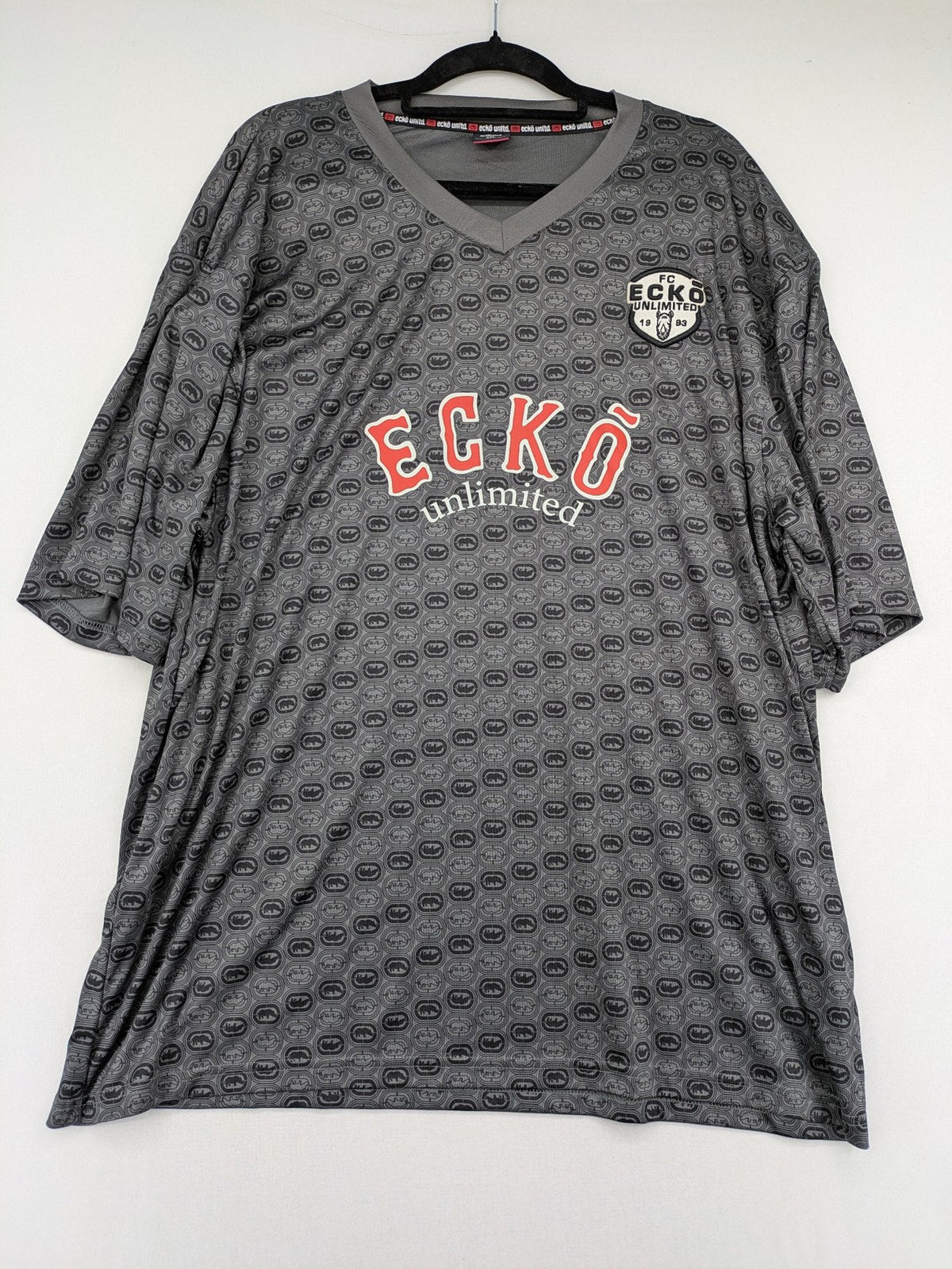 Ecko Unltd. grey soccer uniform V-neck with all-over logo print and embroidered FC patch.