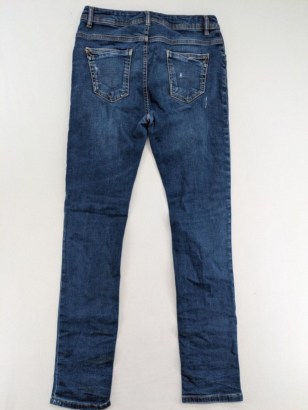 Denim & Co. blue skinny jeans with distressed ripped details and adjustable waistband.