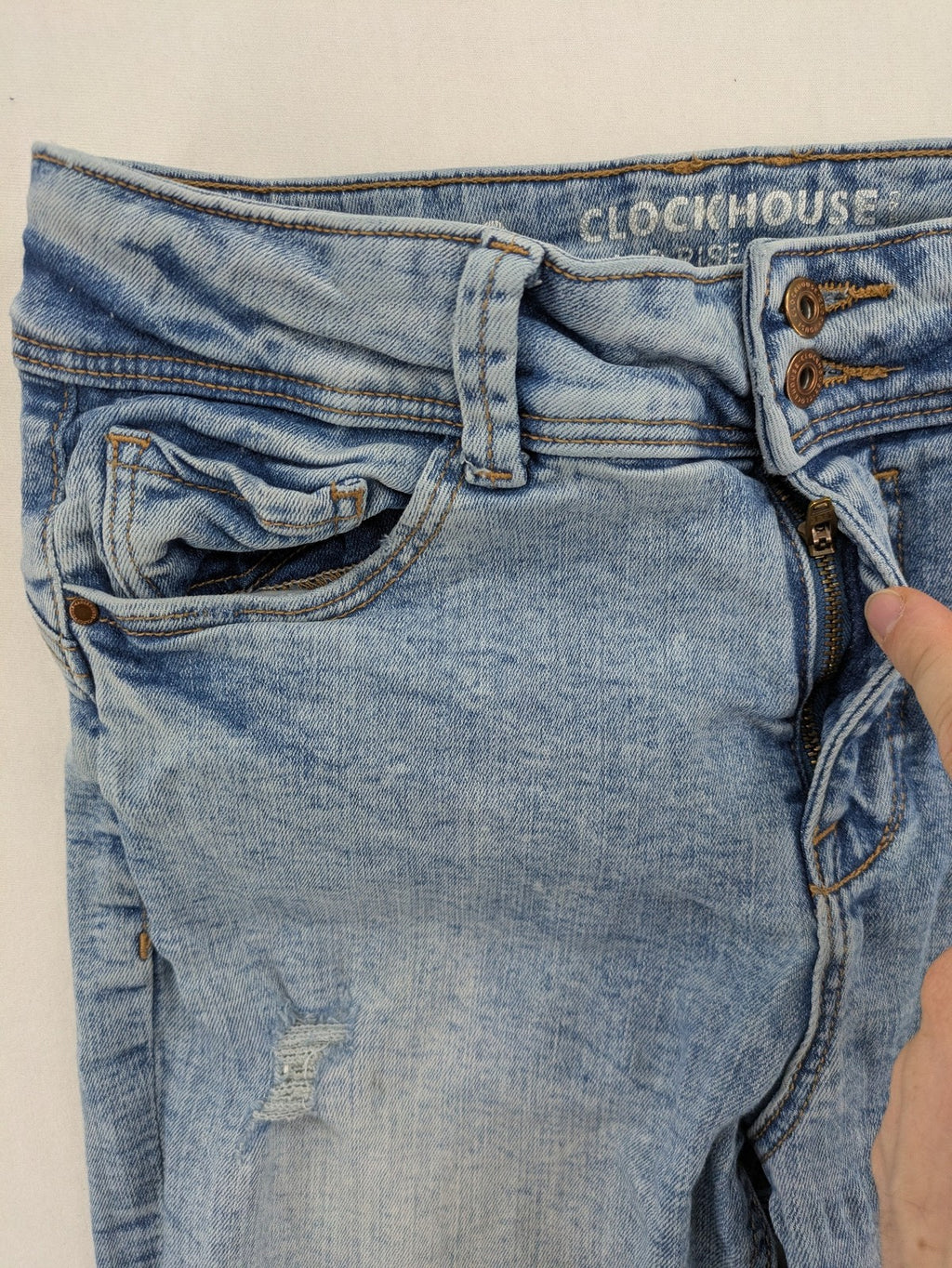 Clockhouse blue skinny jeans with distressed details and frayed hem, mid-rise fit.