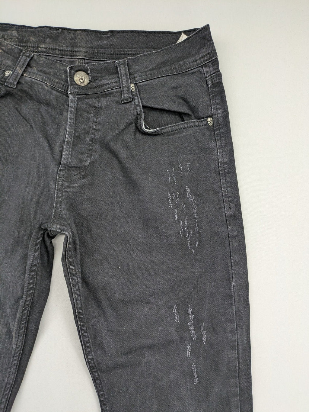 Philipp Plein black straight jeans with distressed finish and skull patch detail.