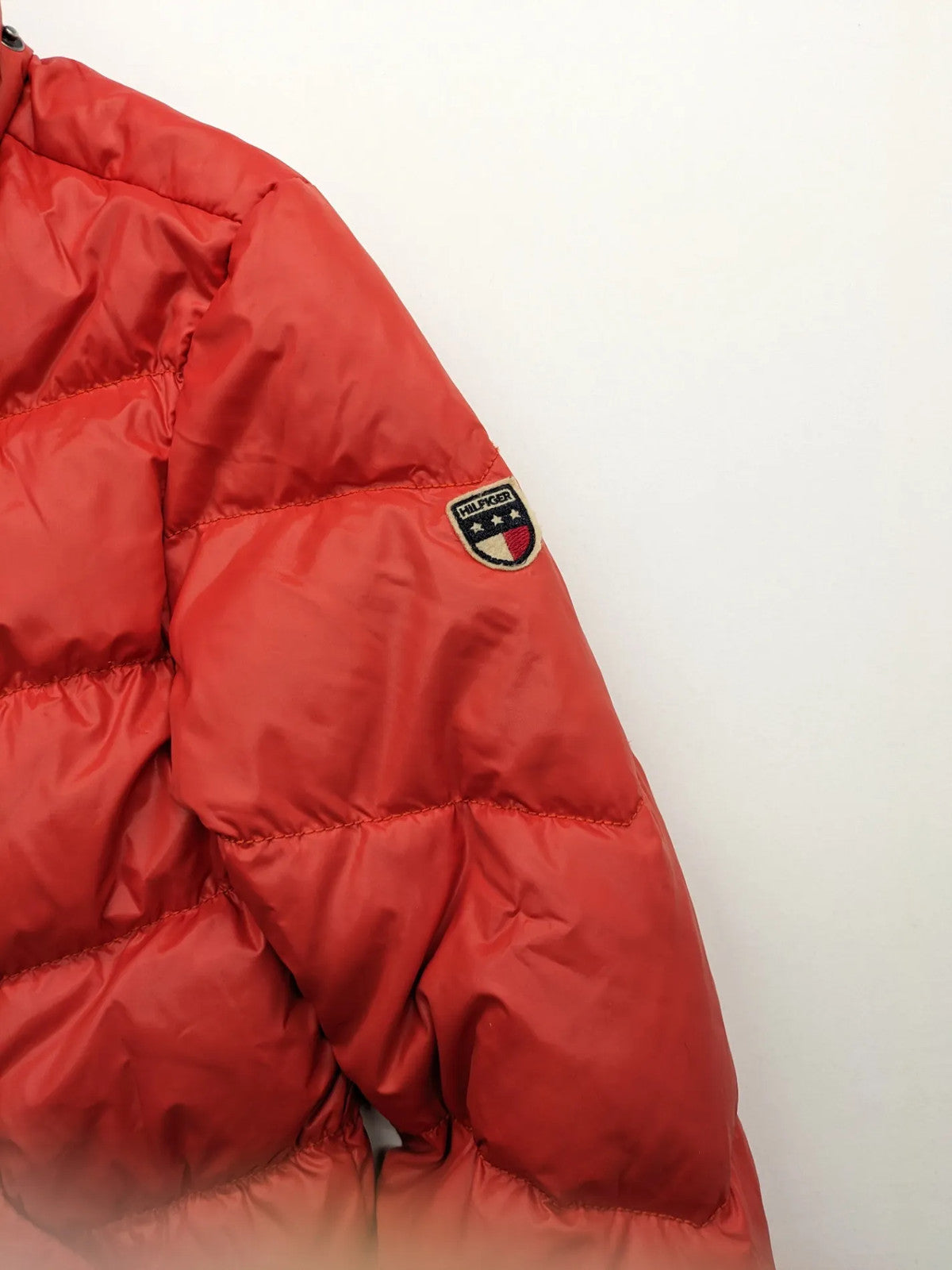 Hilfiger Denim red down jacket with quilted design, stand collar, and zip closure.