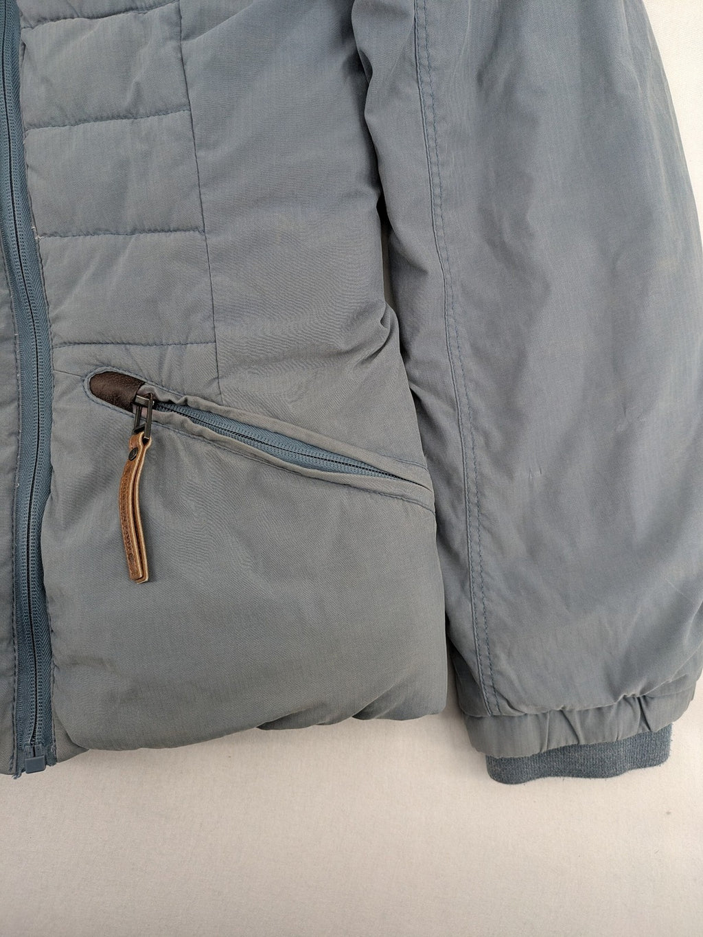 Naketano blue jacket with teddy fleece lining, hood, and leather appliqués.