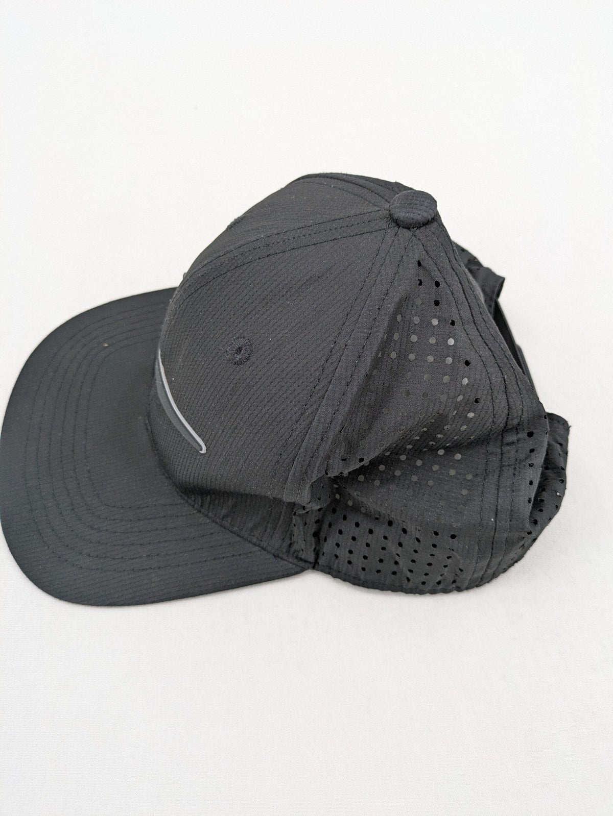 Nike Heritage86 black snapback cap with perforated design and prominent Swoosh logo.