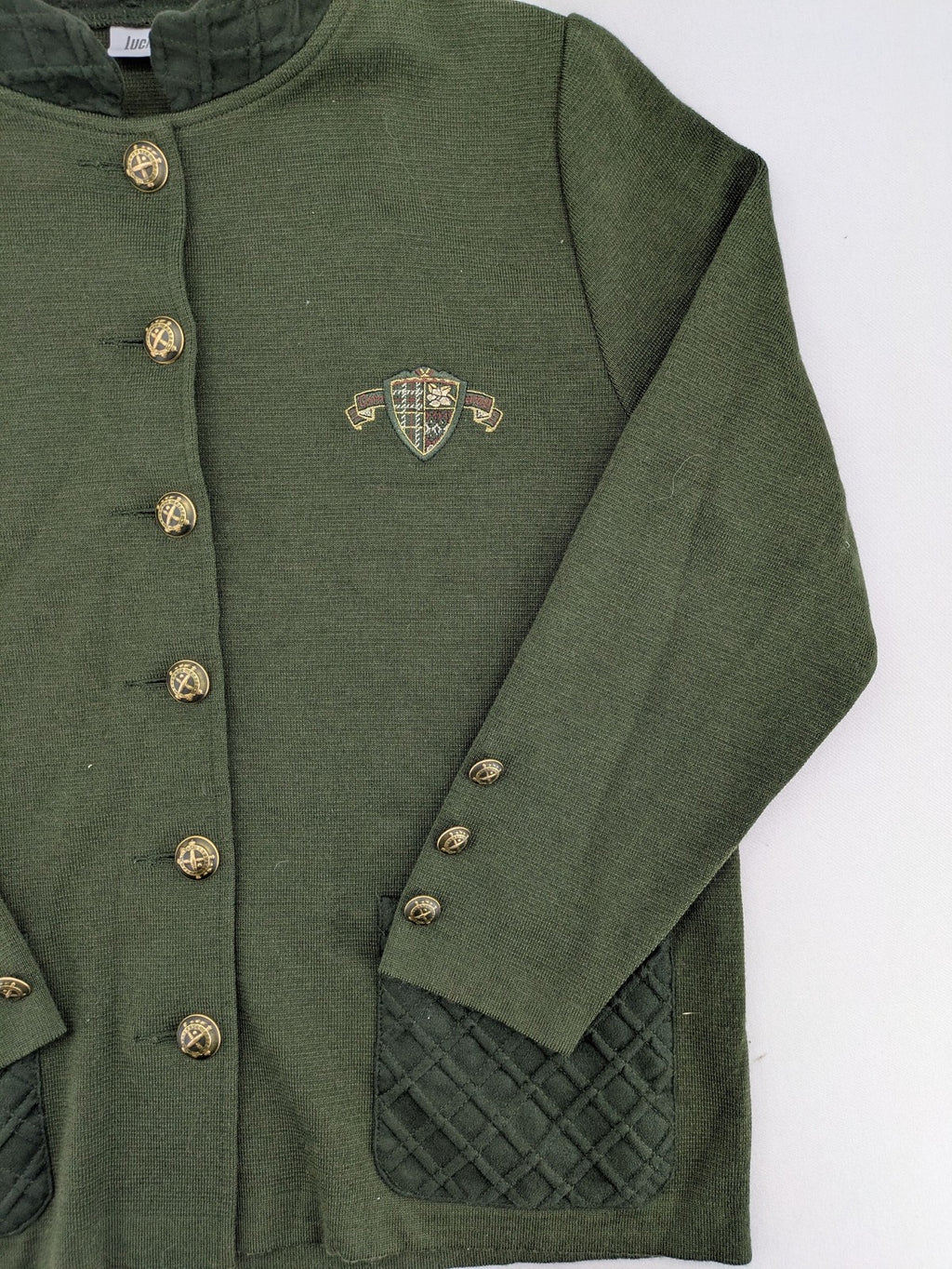 LUCIA green Trachtenjacke with embroidered crest, quilted collar, and decorative buttons.