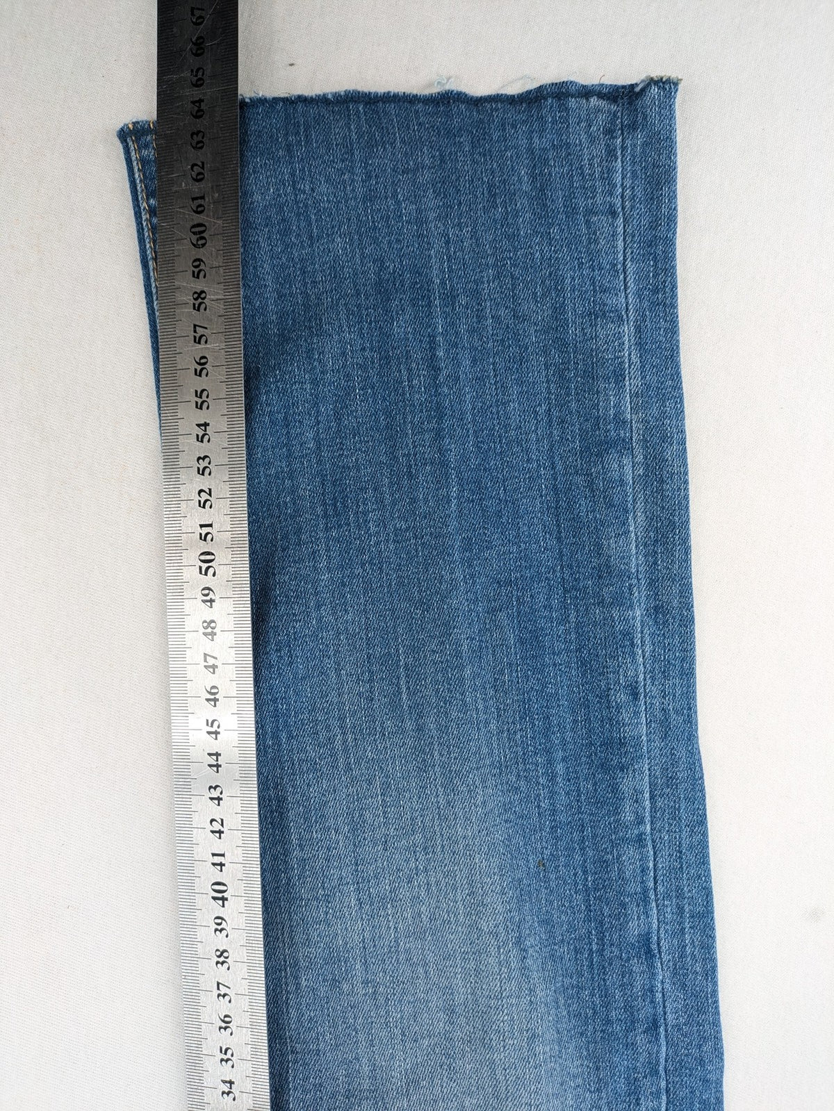 Tally Weijl blue bootcut jeans with distressed knees and raw hem detail.
