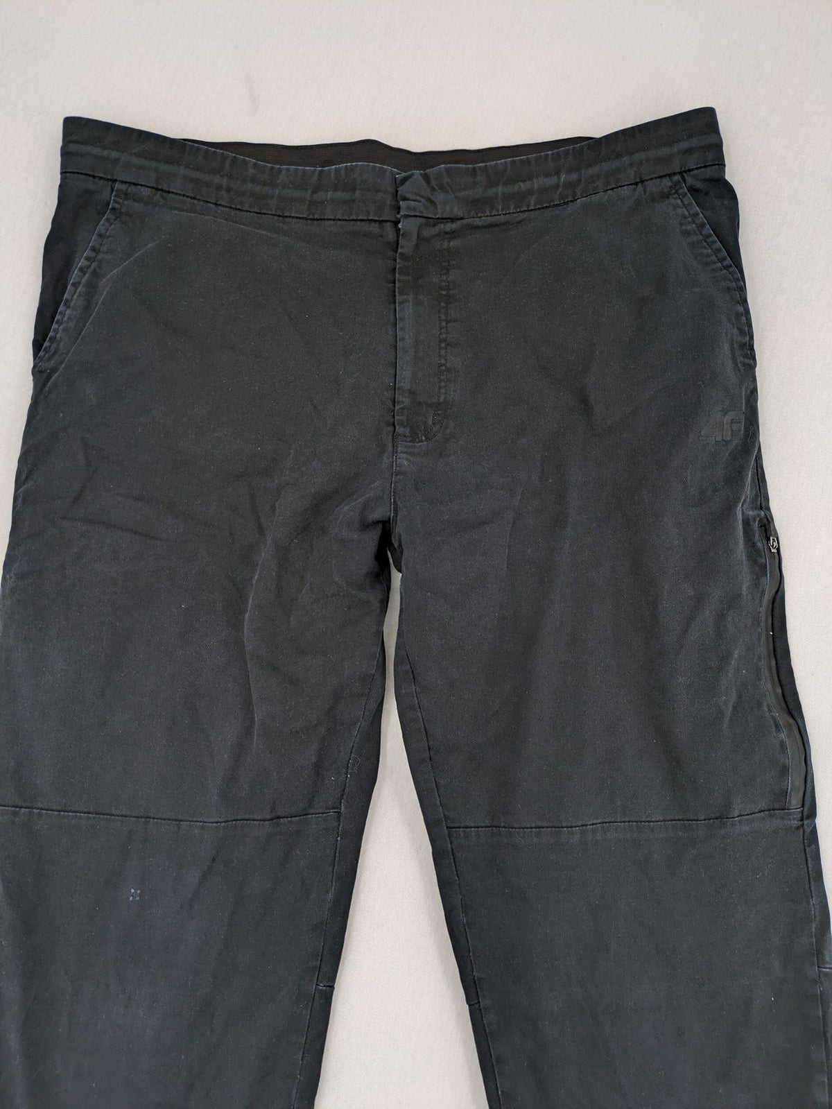 4F black cargo pants with reinforced knees, made from cotton-stretch material.