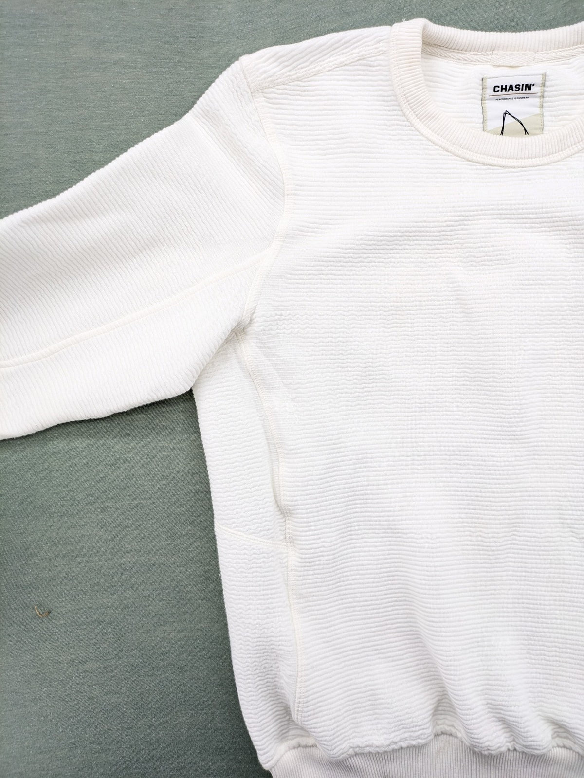 CHASIN' grey and white turtle neck jumper with horizontal ribbed texture and logo patch.