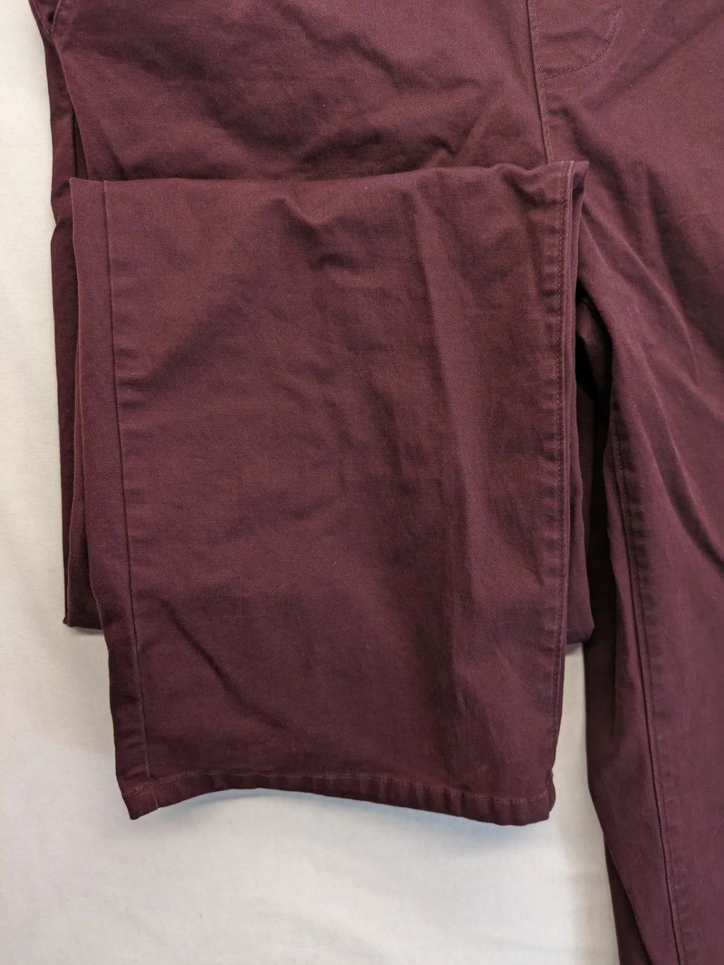Kazane burgundy overalls with adjustable straps, side button placket, and chest pocket.
