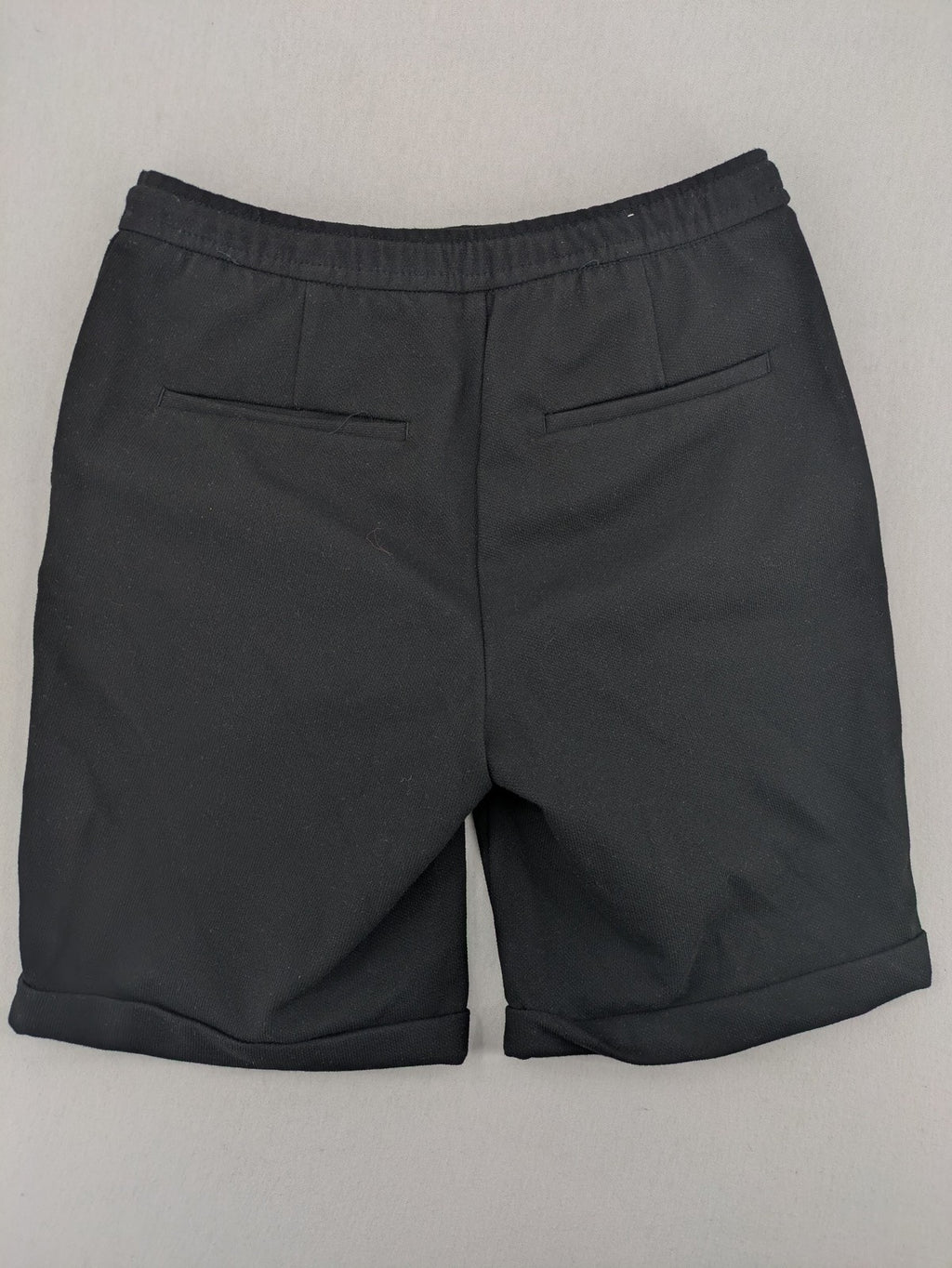 Zara black shorts with elastic drawstring, pleats, and rolled hem detail.