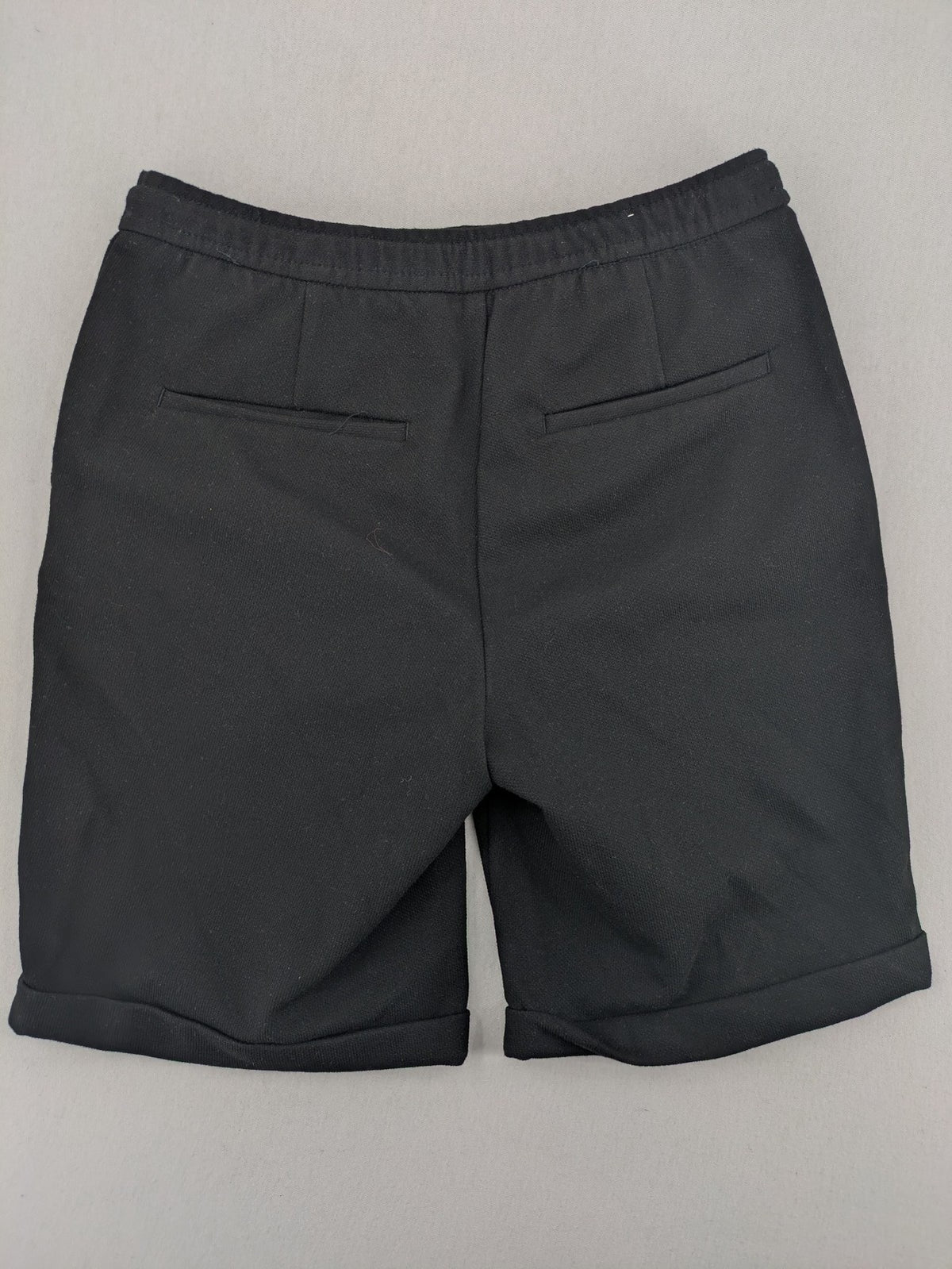 Zara black shorts with elastic drawstring, pleats, and rolled hem detail.