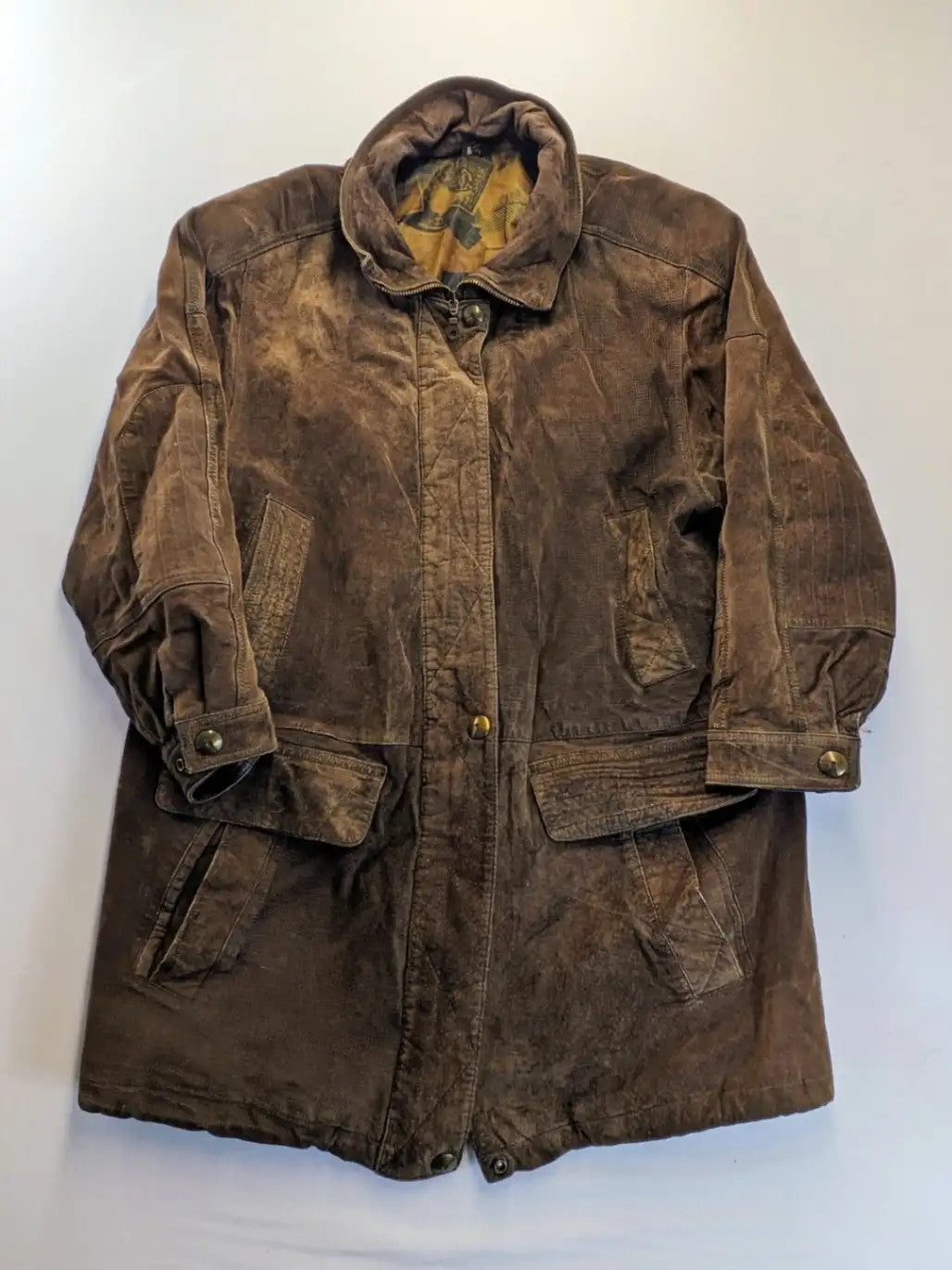 Vintage brown leather jacket with graphic lining, zip closure, and button placket.