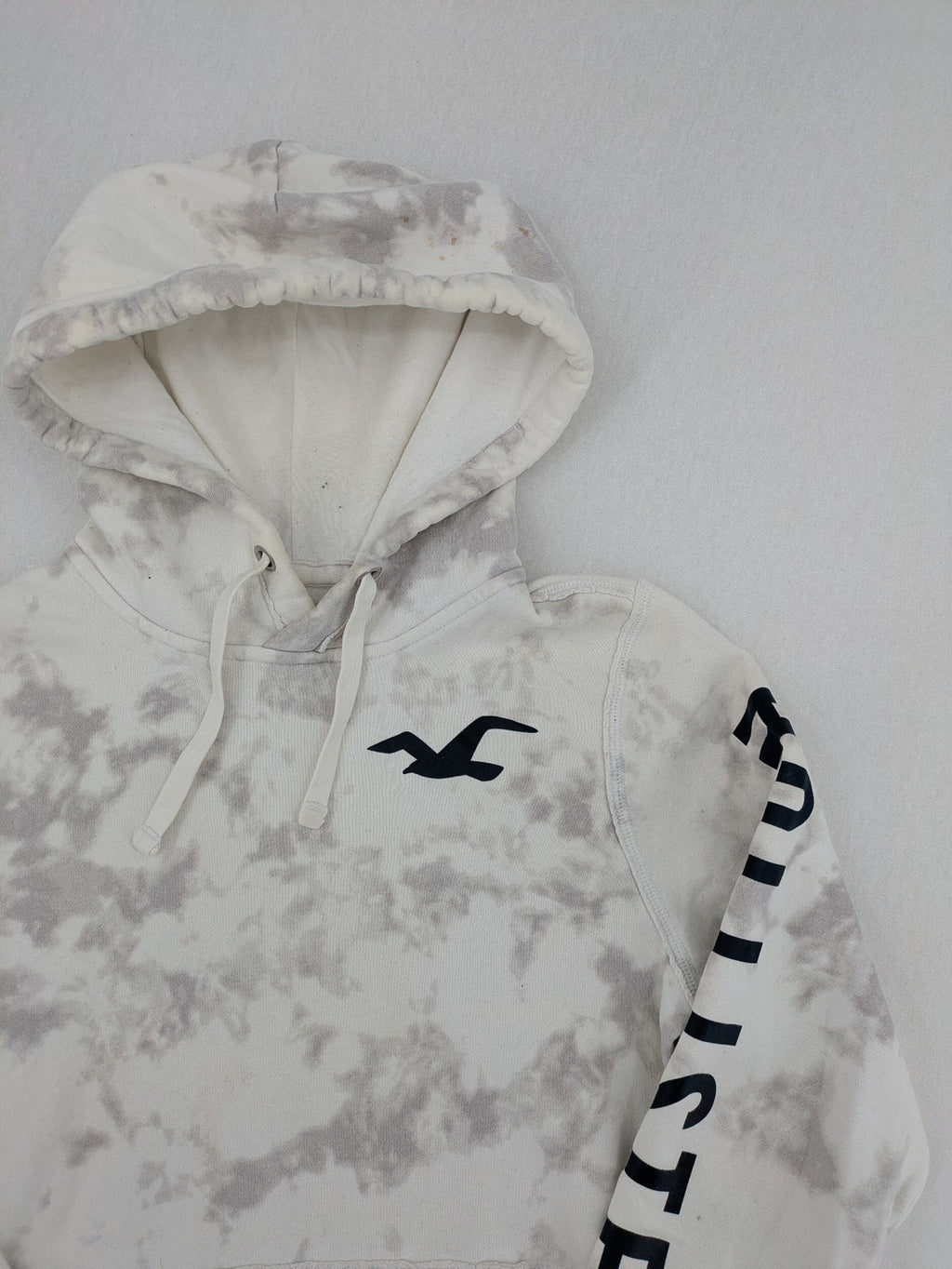 Hollister grey and white tie-dye hoodie with logo on chest, back, and sleeve.