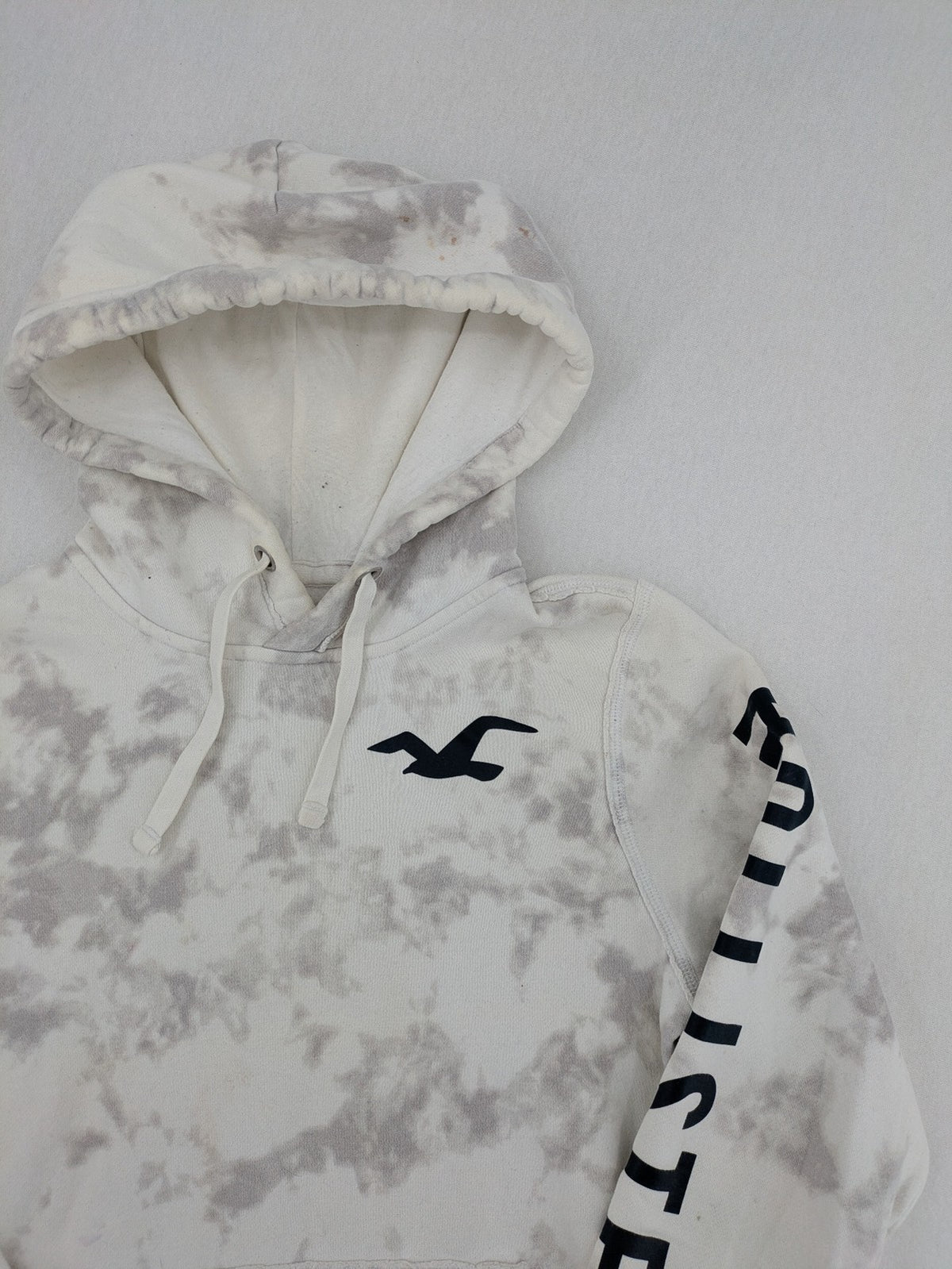 Hollister grey and white tie-dye hoodie with logo on chest, back, and sleeve.