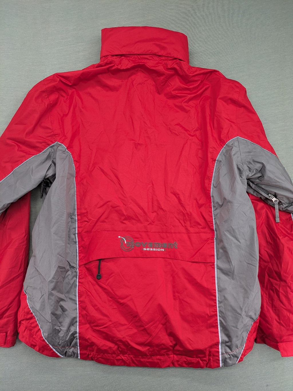 Movement Session grey and red windbreaker jacket with colorblock pattern and full zip.