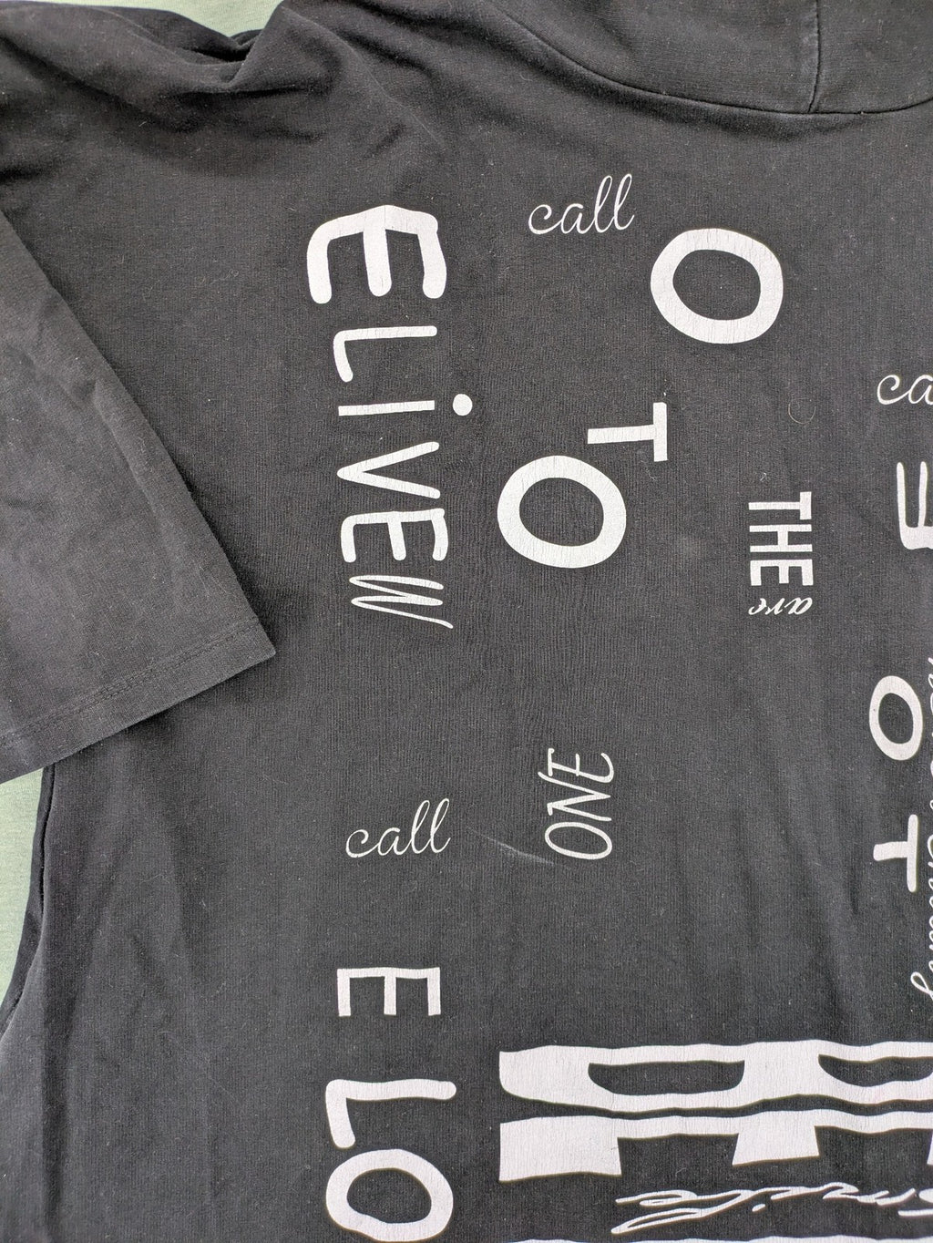 MEGI Collection black hoodie dress with graphic print and asymmetrical high-low hem.