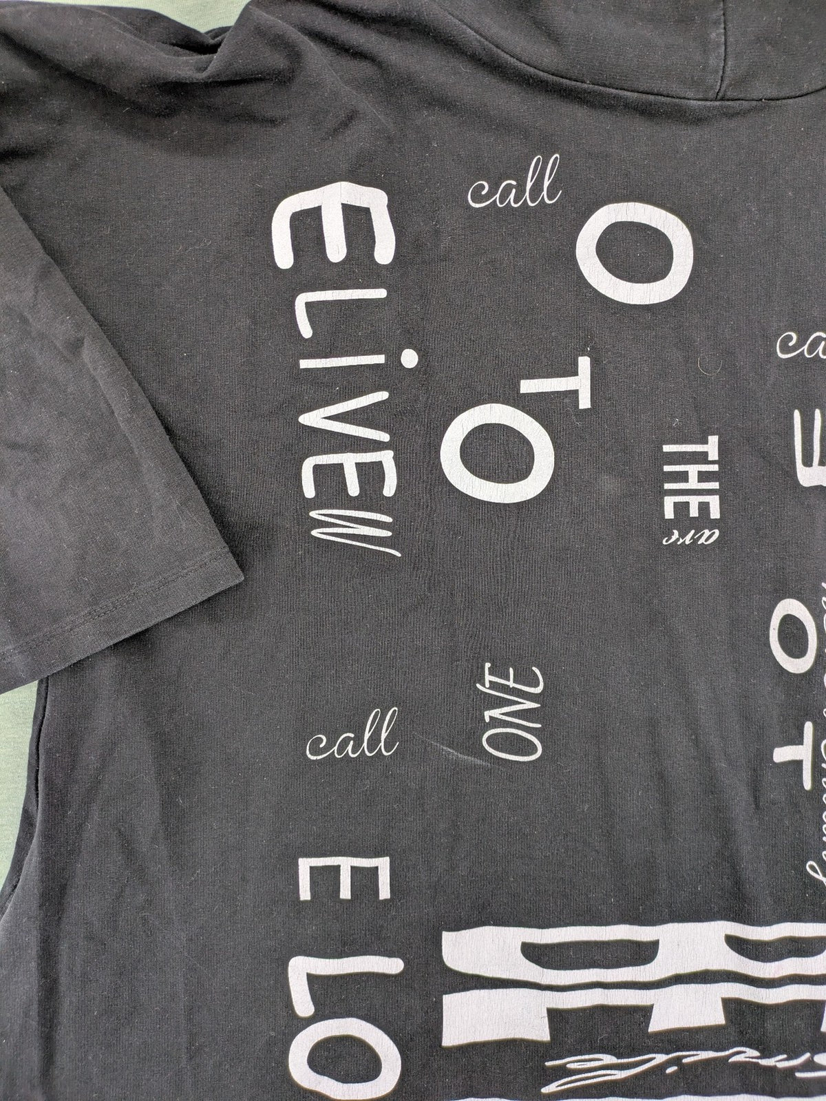 MEGI Collection black hoodie dress with graphic print and asymmetrical high-low hem.