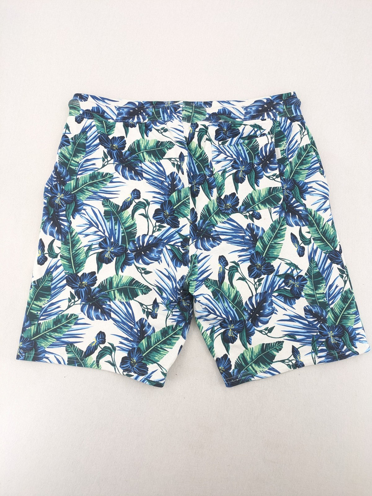 Nils Sundström blue and green tropical floral shorts with white background and elastic waistband.