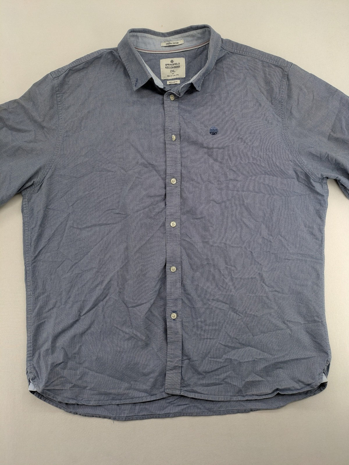Springfield blue Oxford shirt with button placket and subtle logo embroidery.