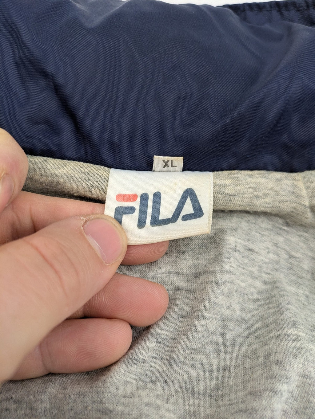 Fila navy windbreaker jacket with large embroidered logo on chest and back.