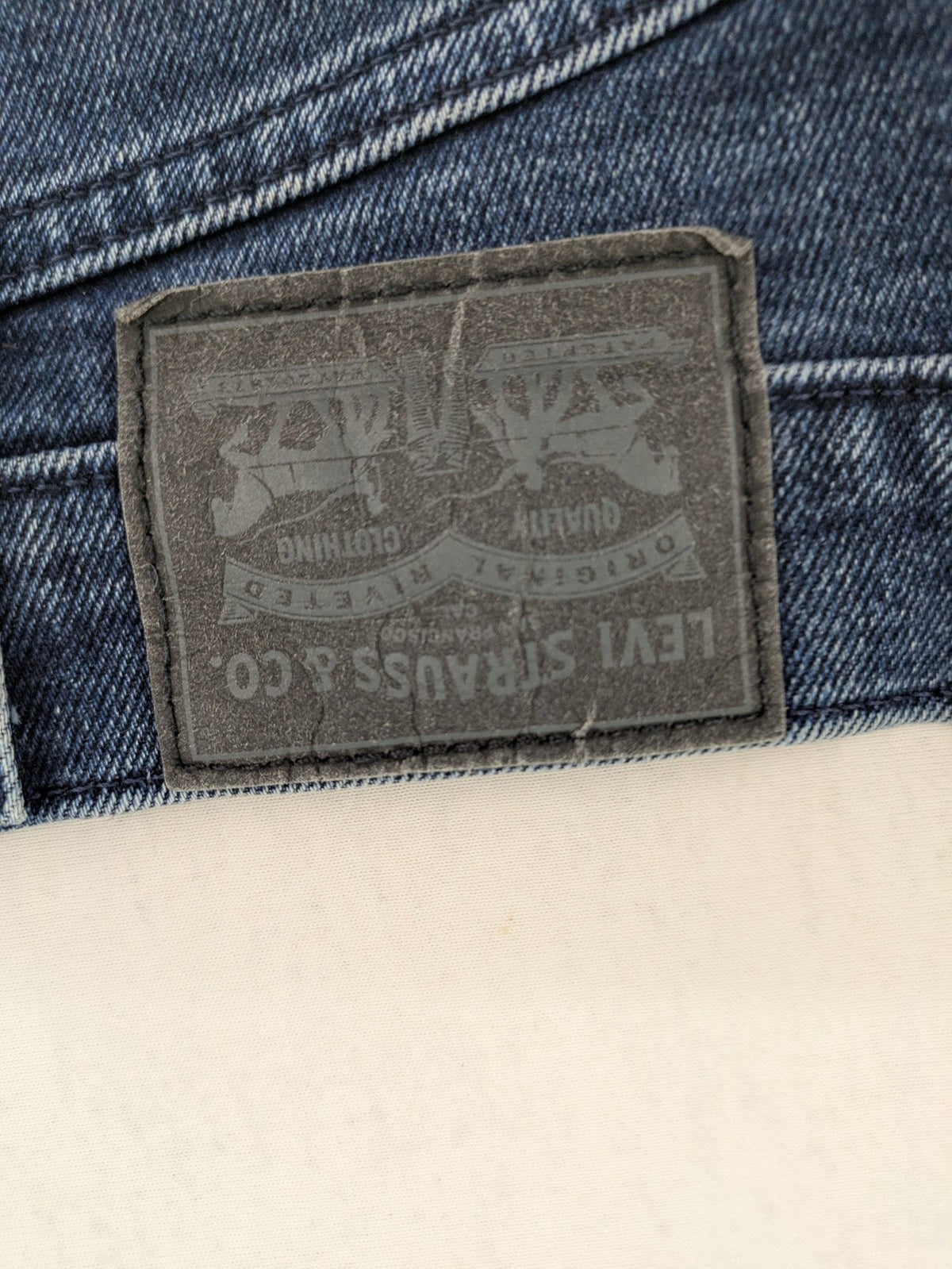 Levi's high waisted taper jeans dark blue 5-pocket design with zipper and stretch material.