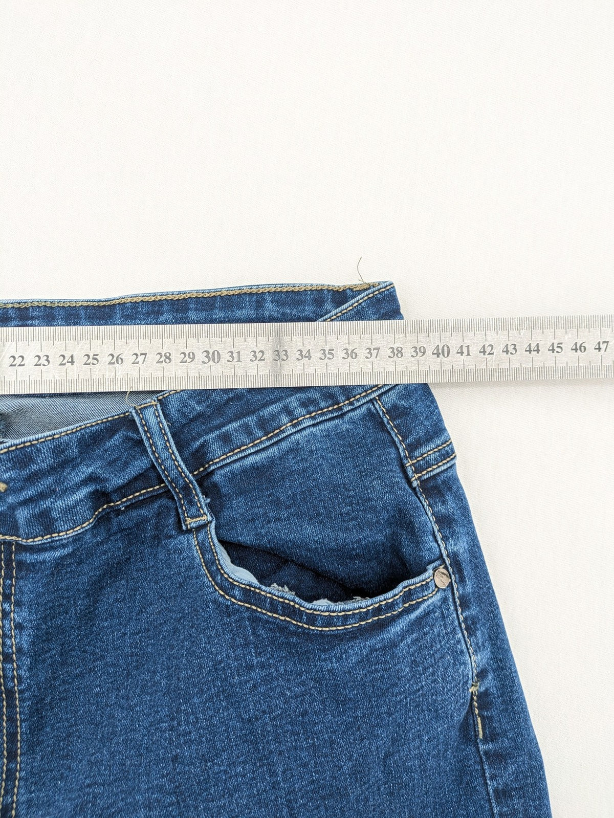 Miss Good blue straight jeans with 5-pocket design and decorative metal accent.
