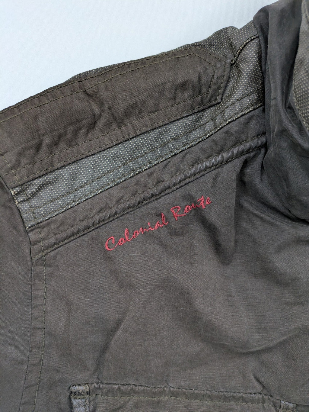 Gate One brown field jacket with plaid lining, multiple pockets, and zip-button closure.
