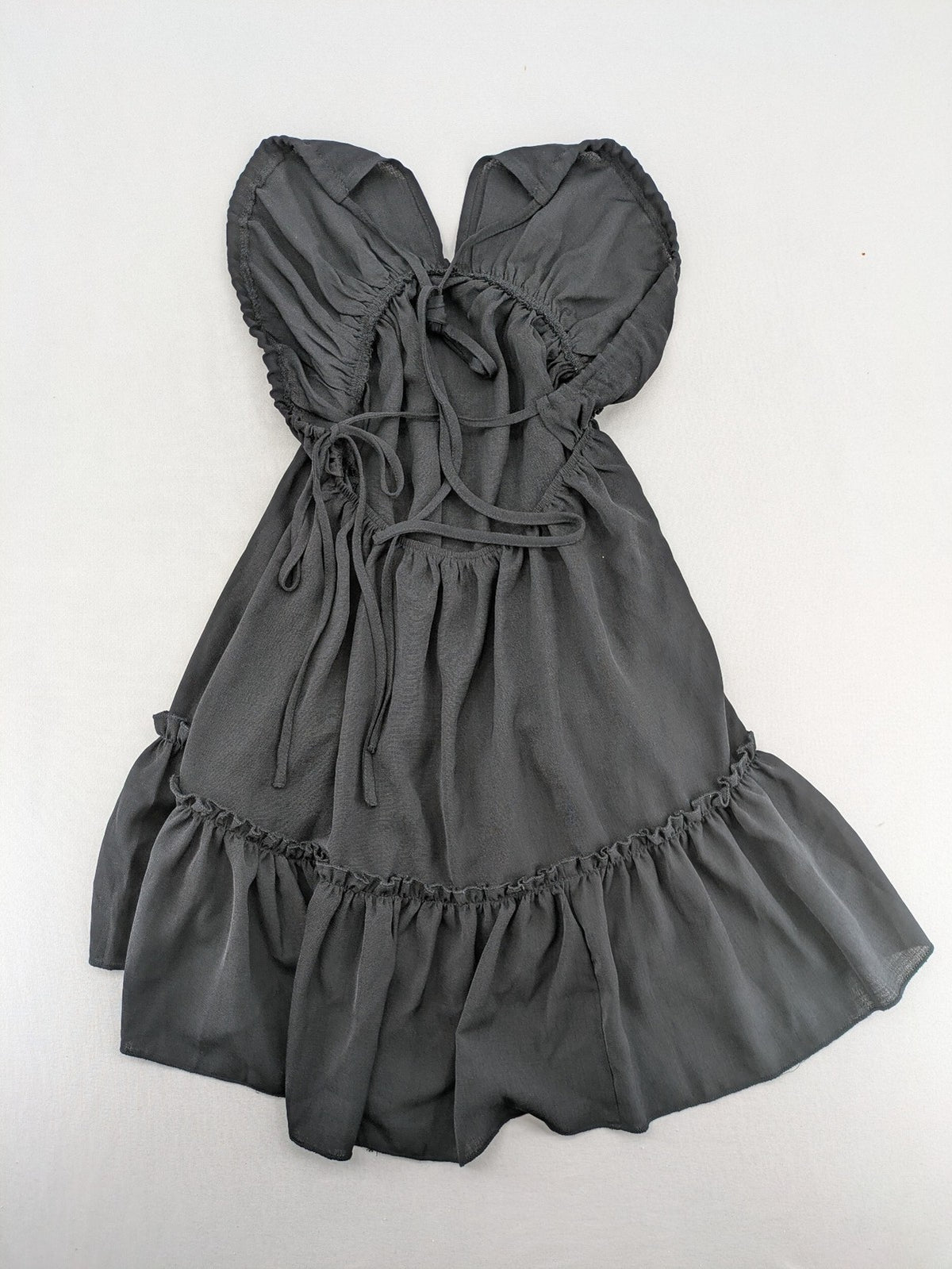SHEIN grey mini dress with open back, adjustable tie, and ruffled hem.
