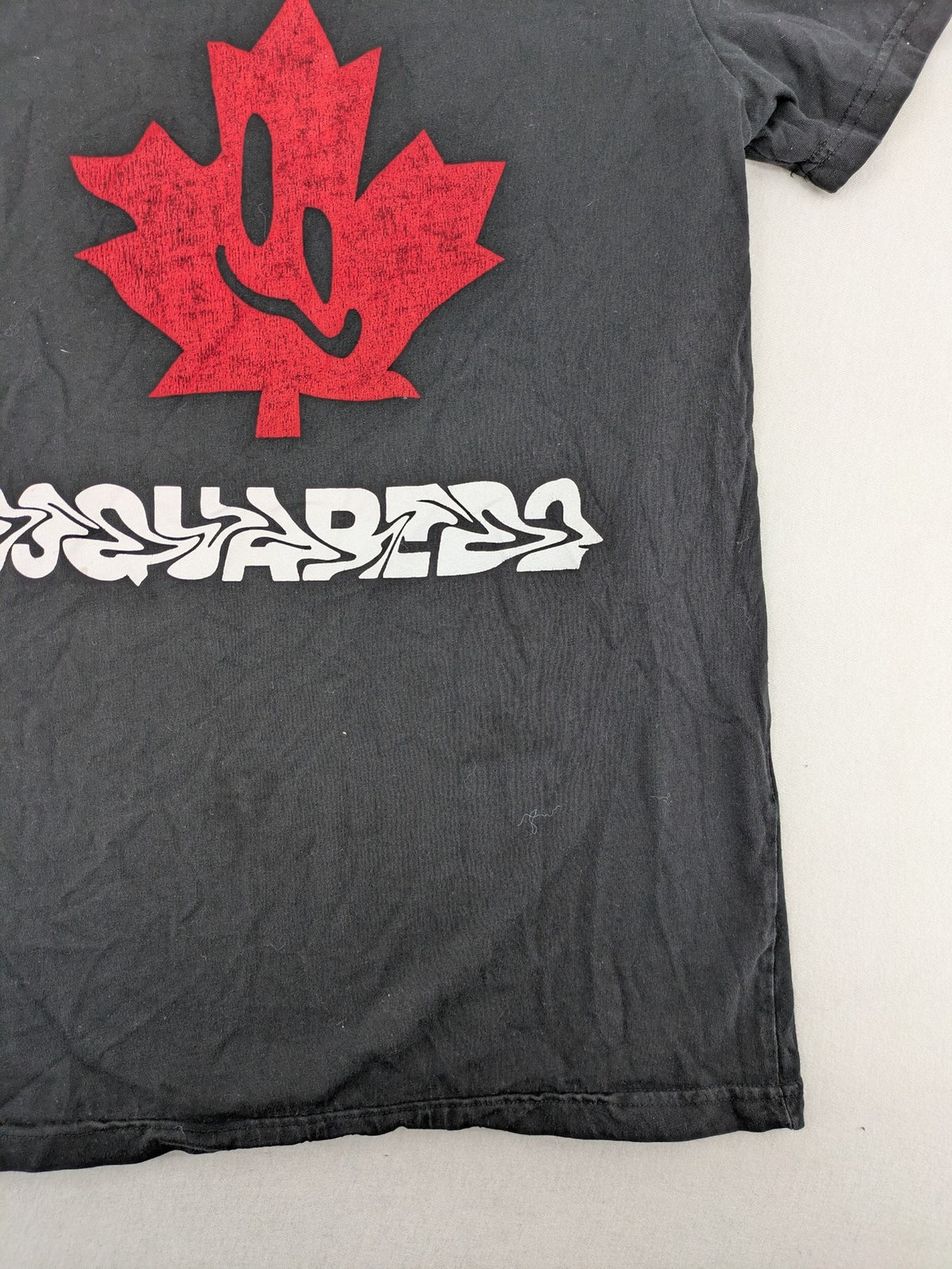 Dsquared2 grey short sleeve shirt with red maple leaf and smiley face graphic.