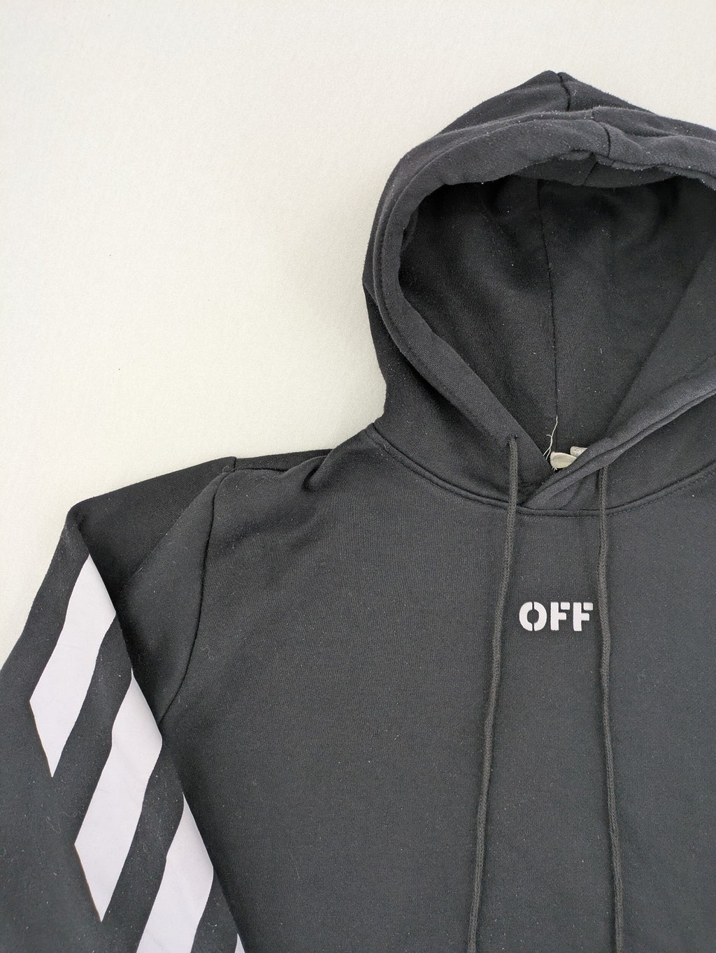 Off-White white zip-through hoodie with diagonal stripes and large arrows graphic.
