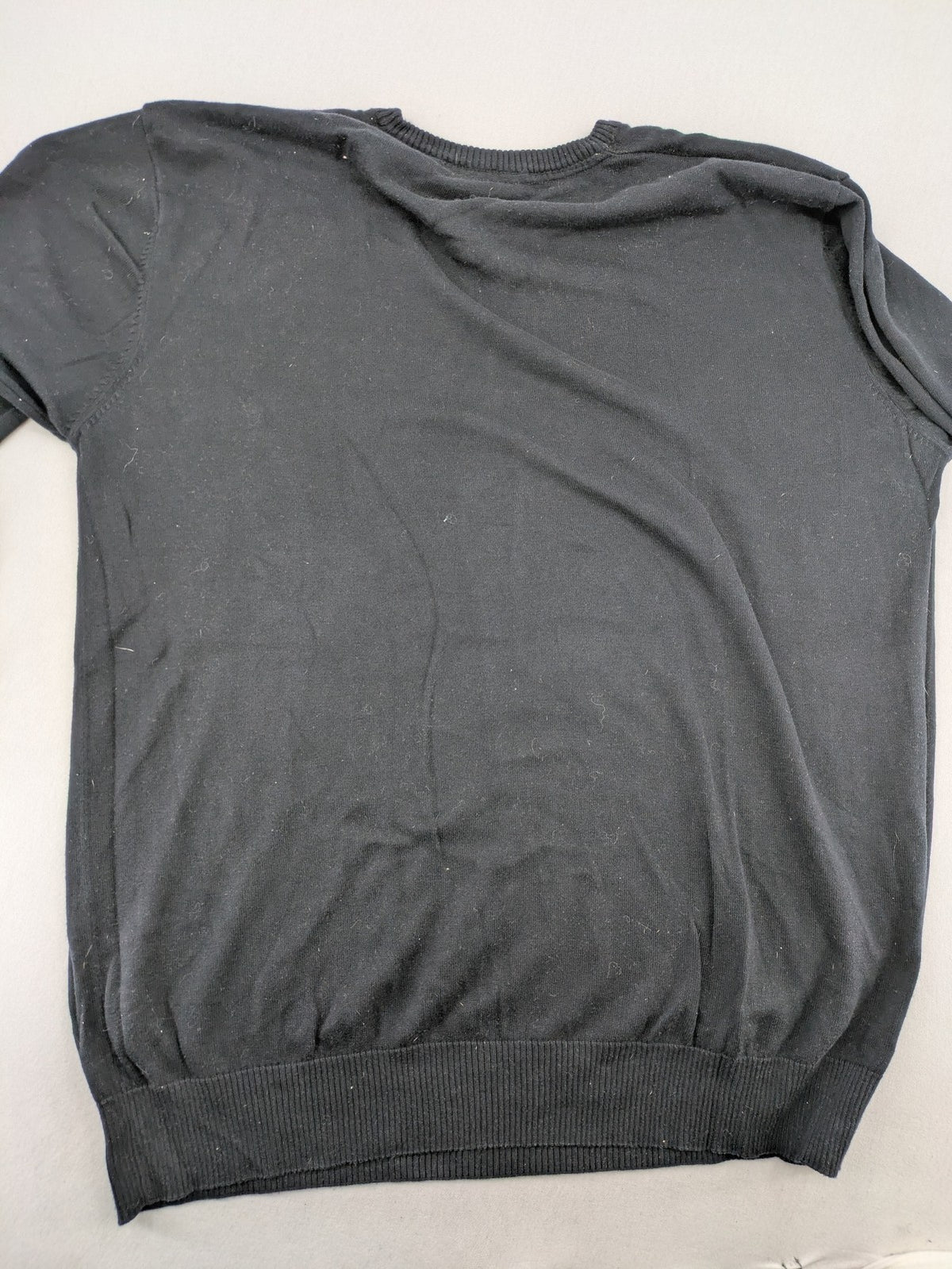 Angelo Litrico black knit jumper V-neck with tonal emblem and "Supreme Oil Quality" graphic.