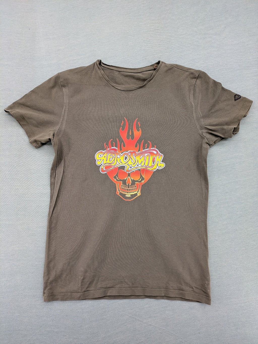 Aerosmith khaki band t-shirt featuring large flaming skull graphic and logo, slim fit.